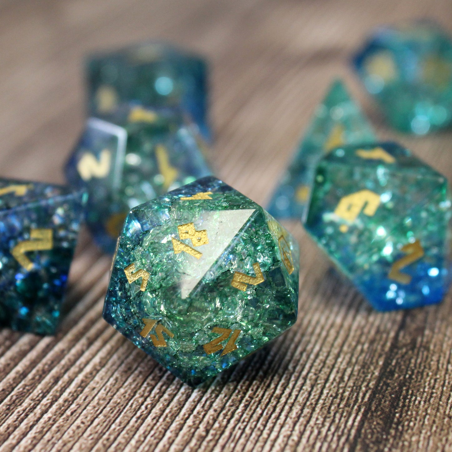 Arctic Wave Shattered Glass Dice Set on wood with D20 in focus, ideal for winter campaigns in Dungeons and Dragons.