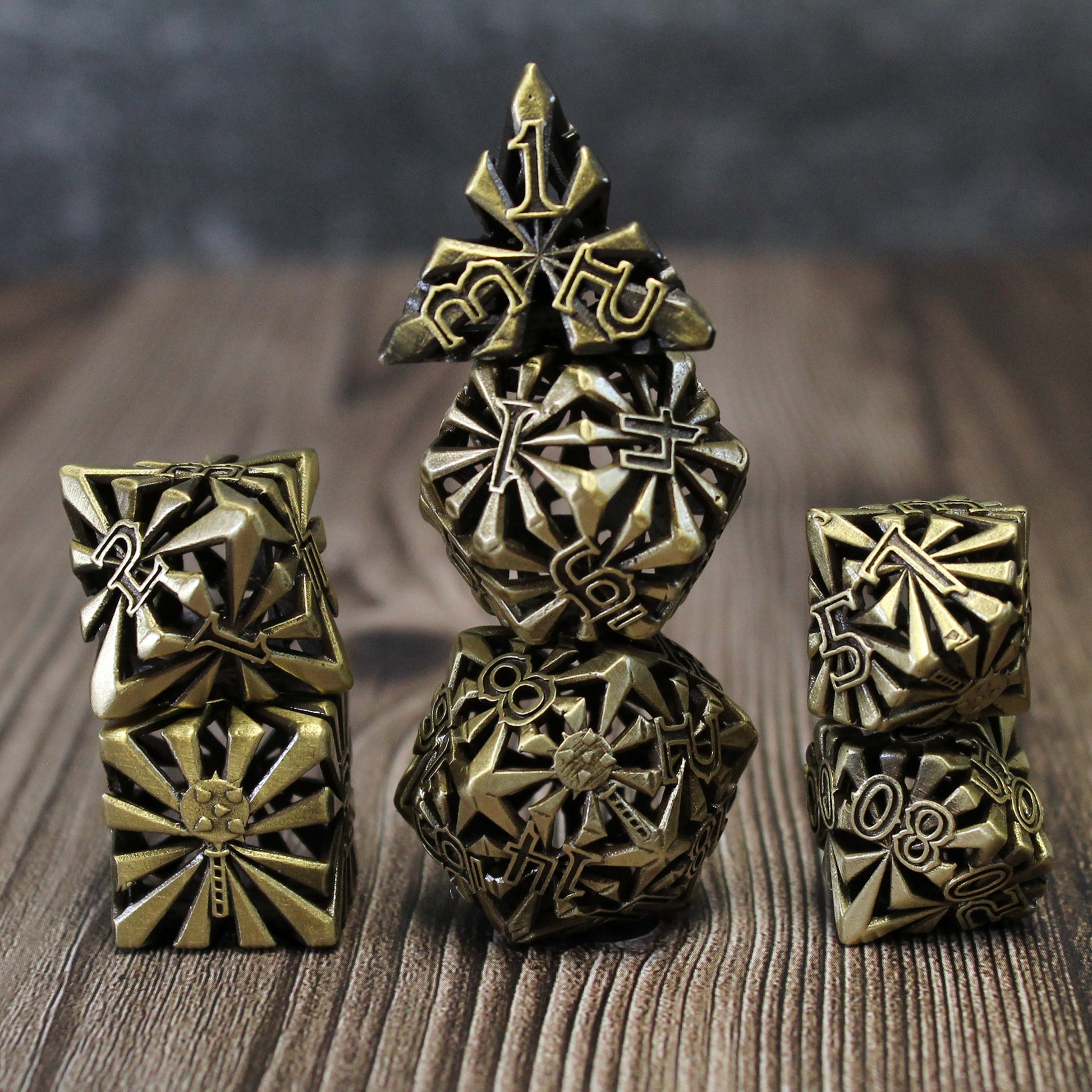 Stacked set of seven bronze cleric-inspired hollow metal dice with uninked numbers and a mace in place of the high number on each die on a wooden background