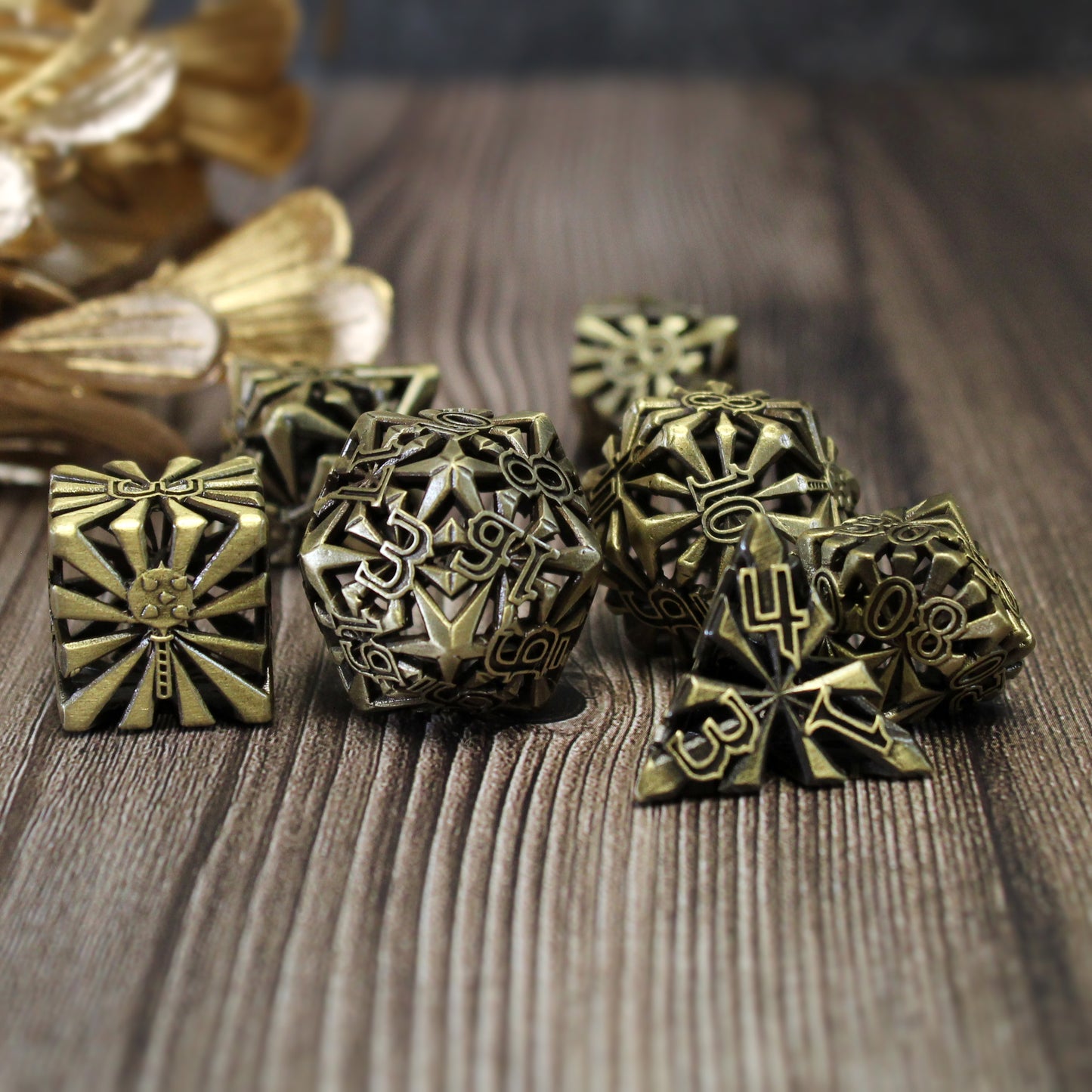 set of seven bronze cleric-inspired hollow metal dice with uninked numbers and a mace in place of the high number on each die on a wooden background