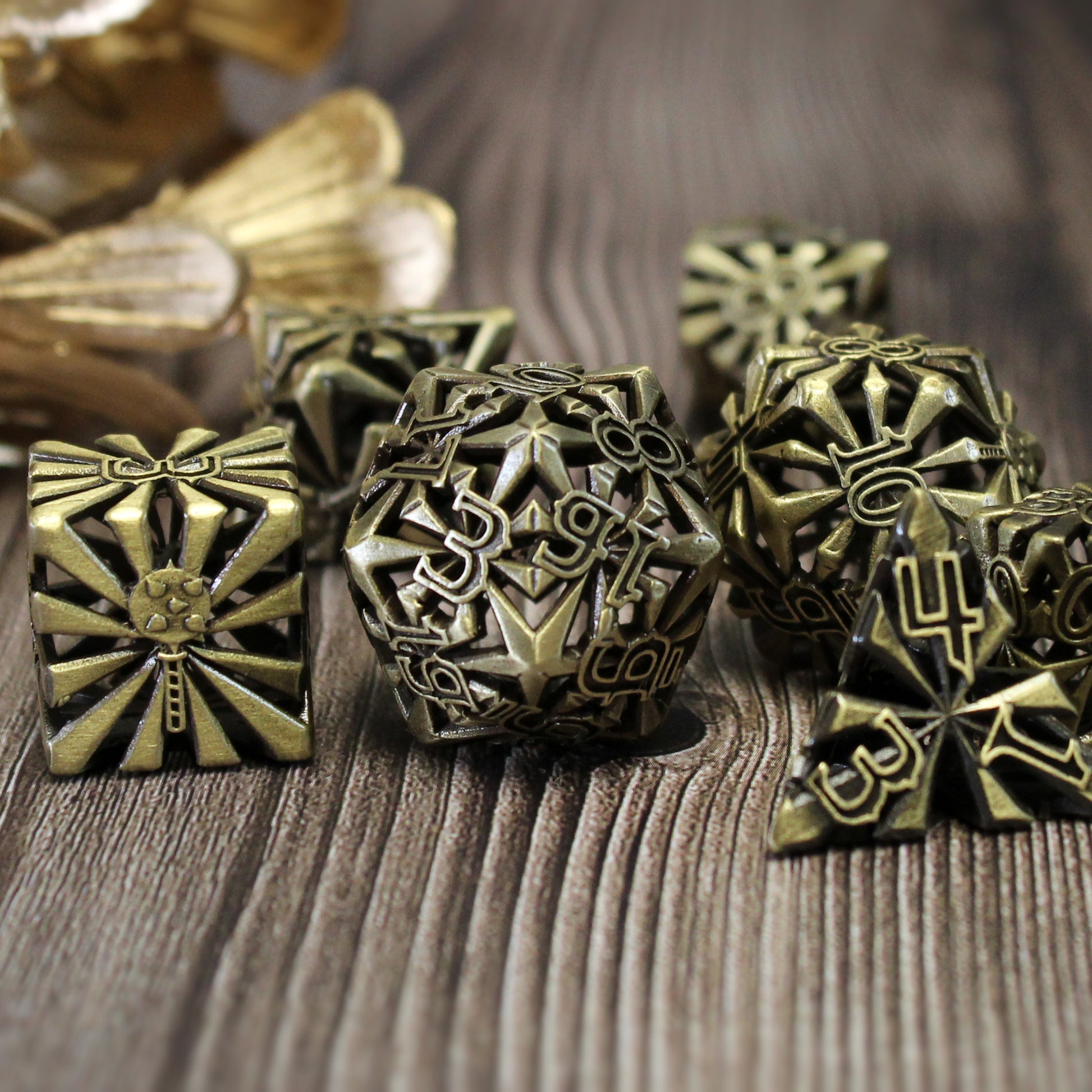 set of seven bronze cleric-inspired hollow metal dice with uninked numbers and a mace in place of the high number on each die on a wooden background