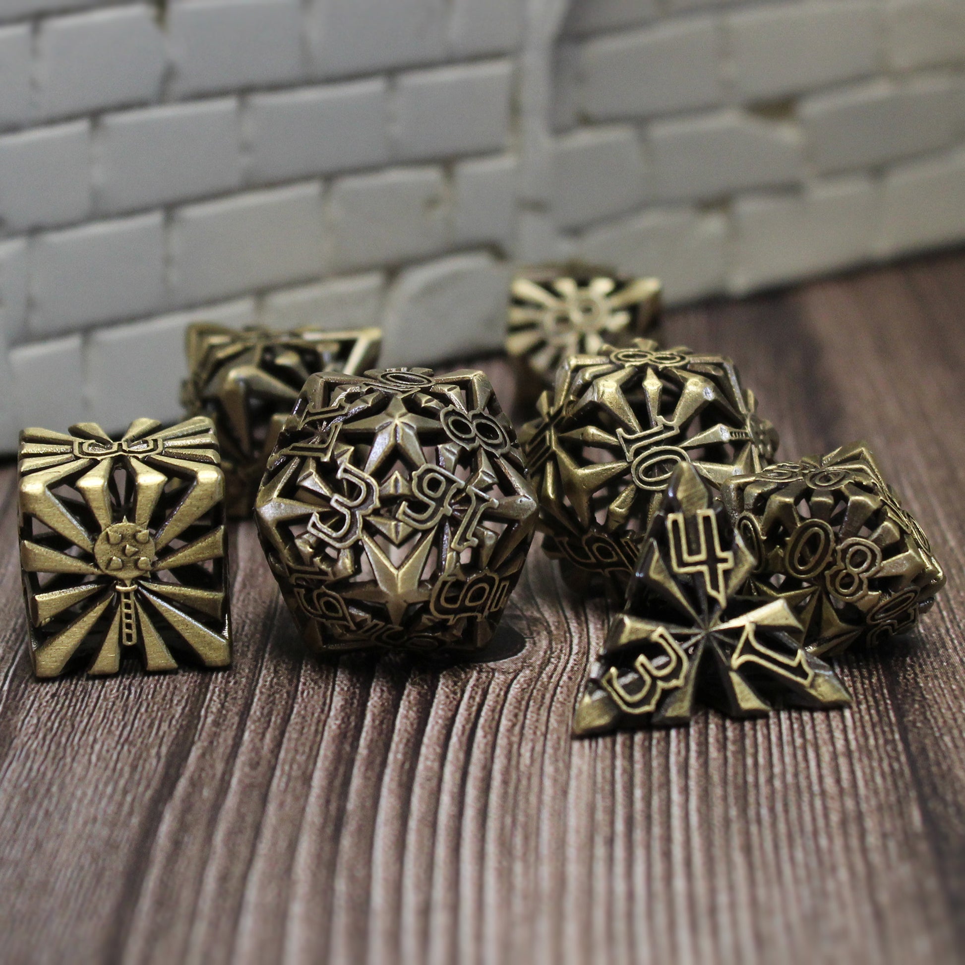 set of seven bronze cleric-inspired hollow metal dice with uninked numbers and a mace in place of the high number on each die on a wooden background