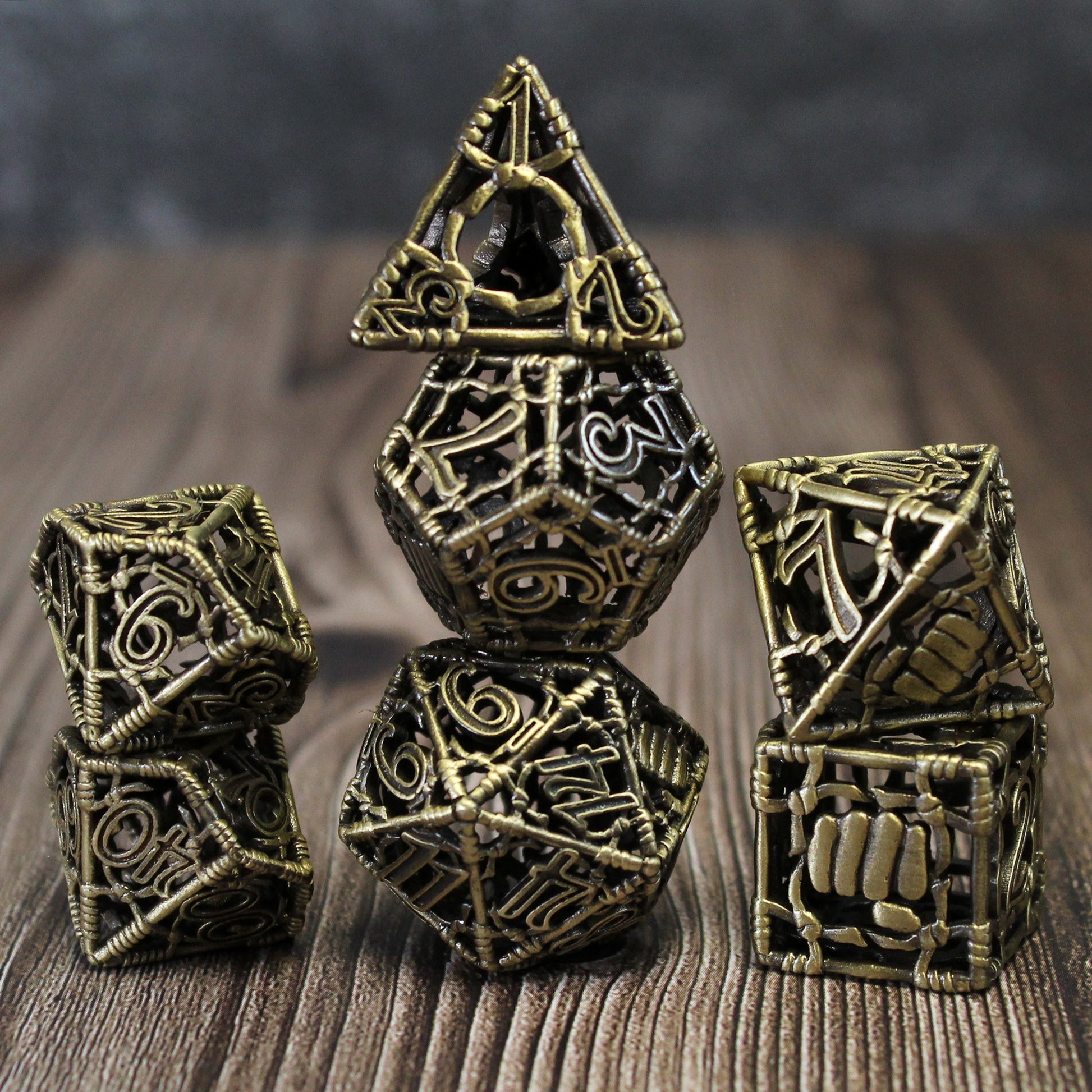 All 7 bronze dice piled up in 3 stacks. Two dice in first stack, three dice in second stack, two dice in third stack. All on a wood paneled surface with a grey background.