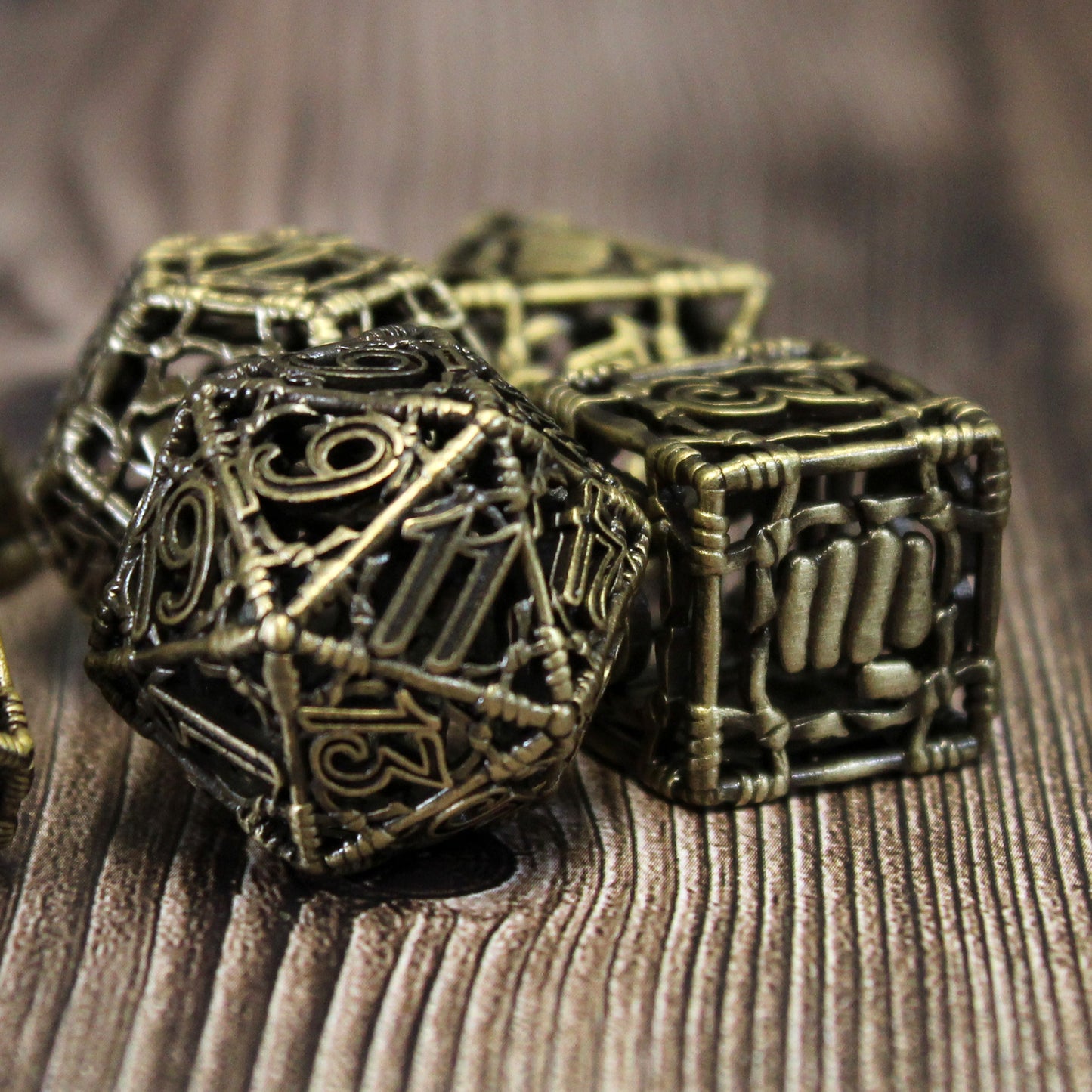 20 sided die in focus, with three other die slightly out of focus around it. All on a wood paneled surface.