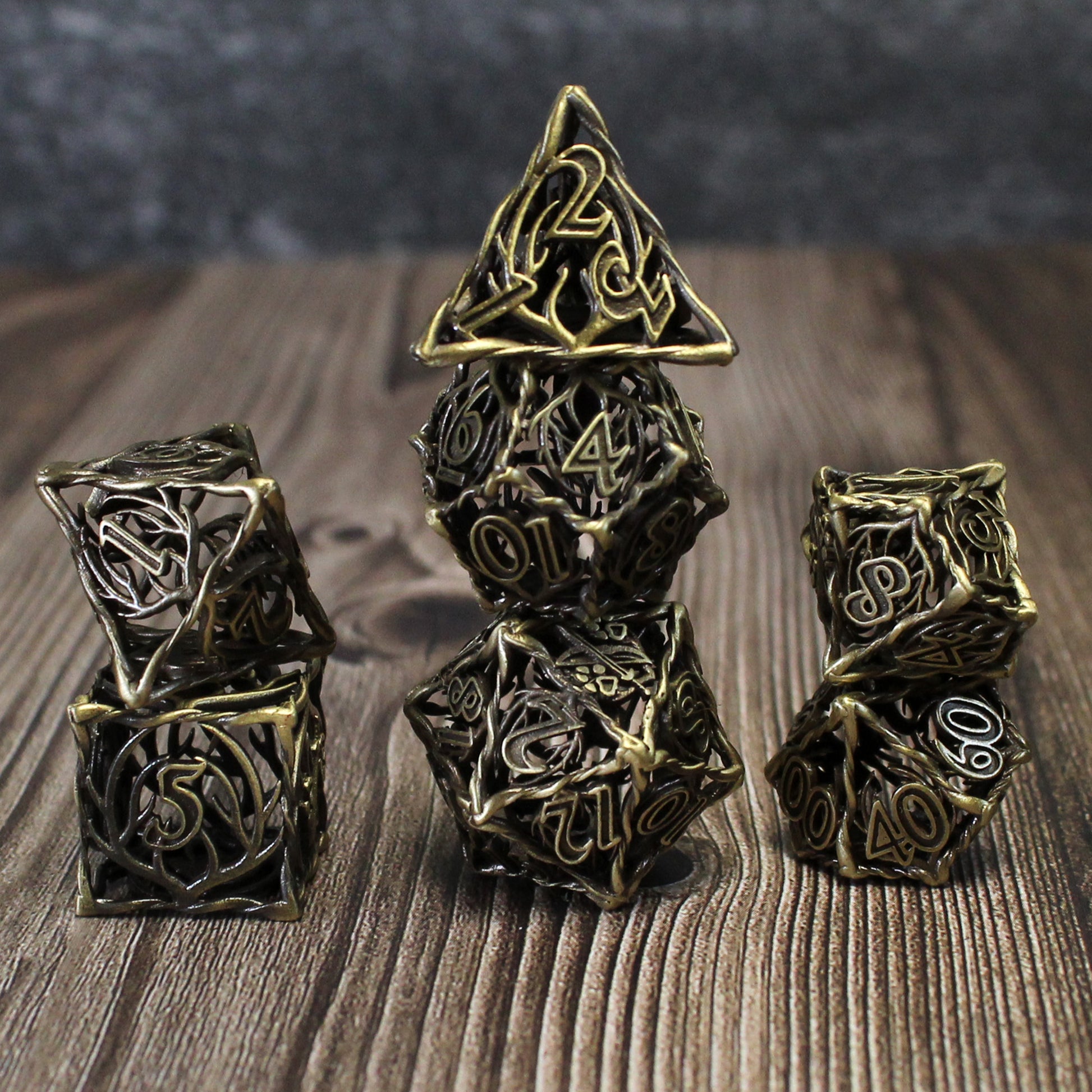 Bronze Ranger Cage dice set arranged in three columns on a wood surface.