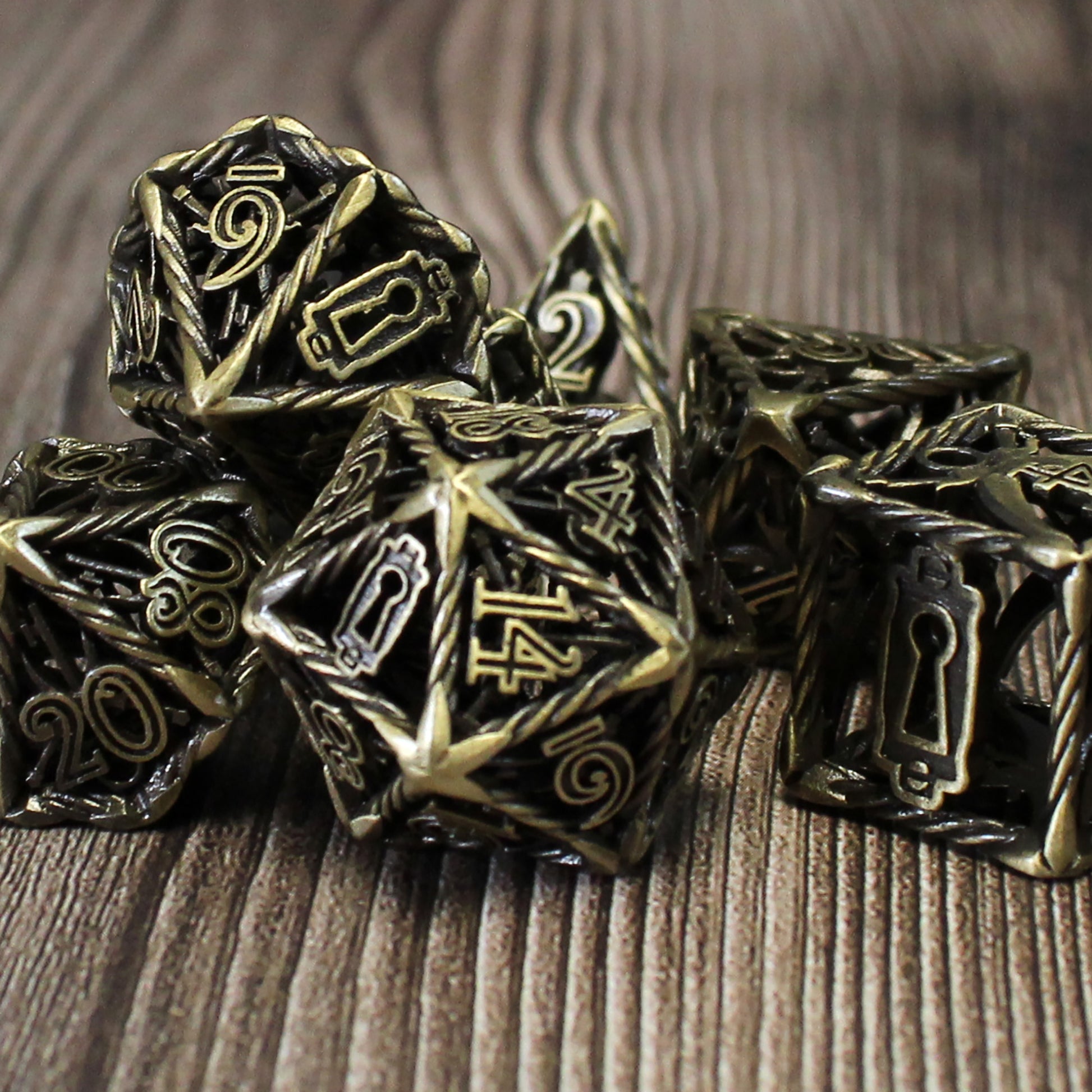 Bronze Rogue Cage dice set arranged in a pile on a wood surface.