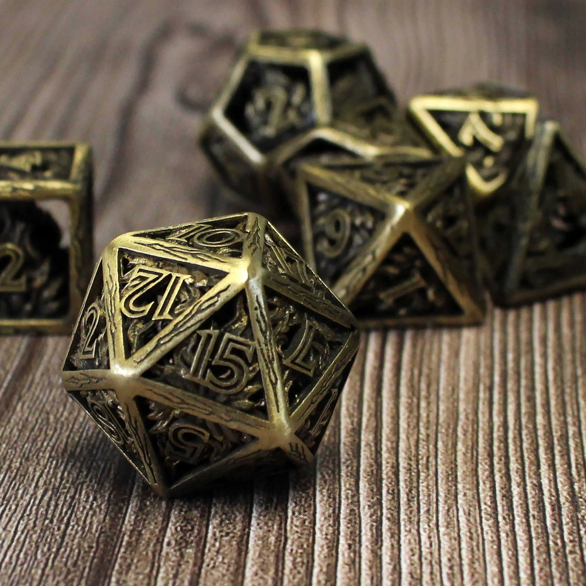 20 sided die in foreground, with 5 other dice blurred in background. All on a wood paneled surface.