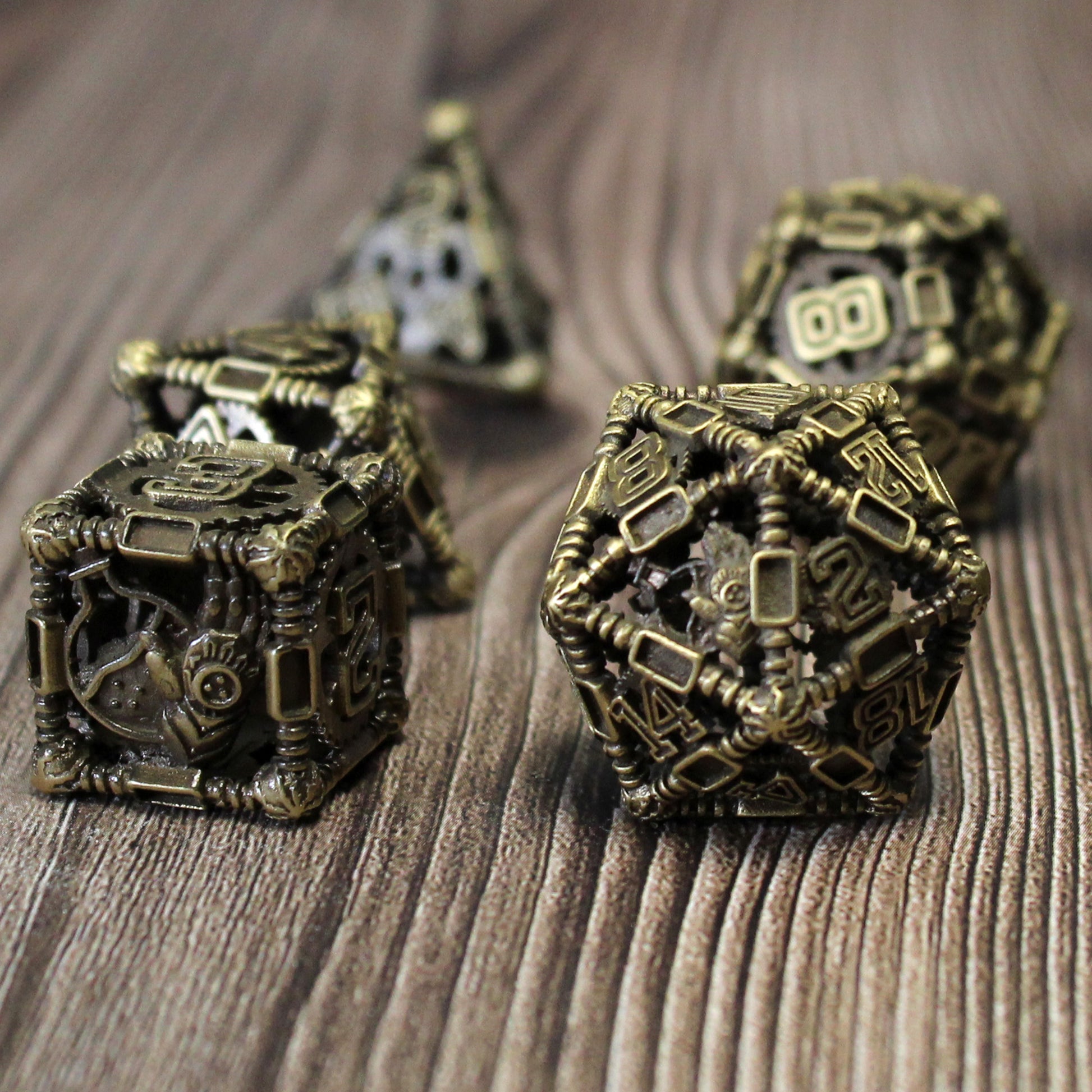 6 sided and 12 sided die in foreground, with three other dice blurred in background. All on wood paneled surface.