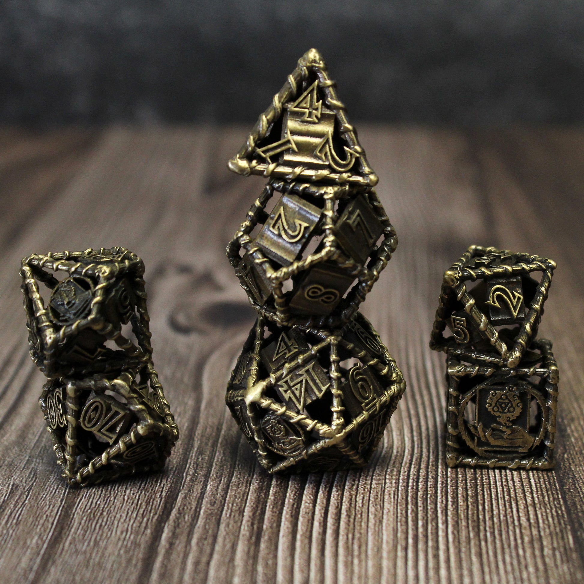 All 7 bronze dice piled up in 3 stacks. Two dice in first stack, three dice in second stack, two dice in third stack. All on a wood paneled surface.