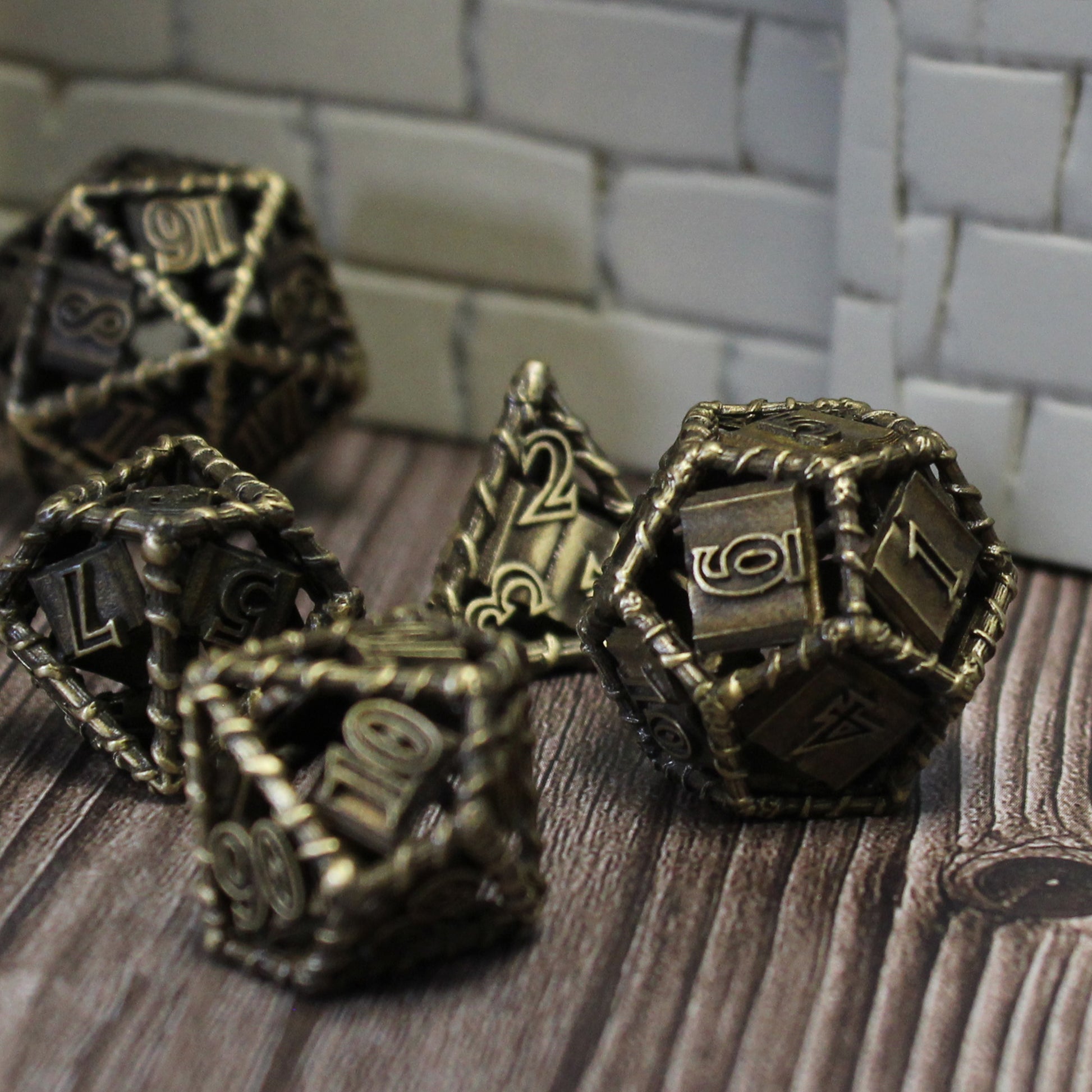 Five of the bronze dice on a wood paneled surface, and a white tiled background