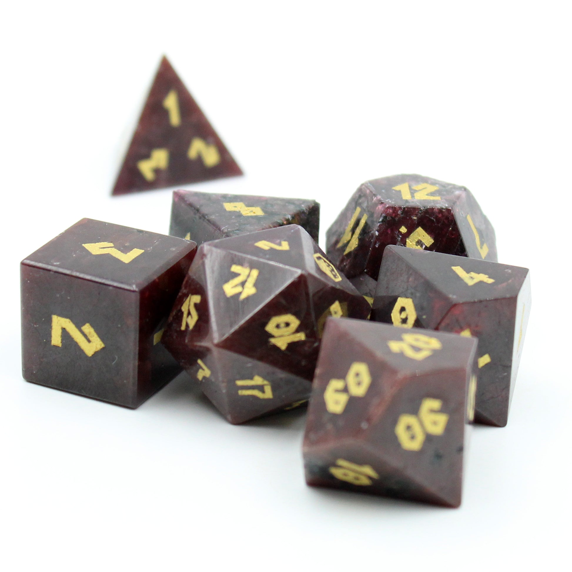 Grouped Garnet gemstone dice set, featuring Romanesque gold numbering on the rich brownish-red stone, ideal for TTRPG play.