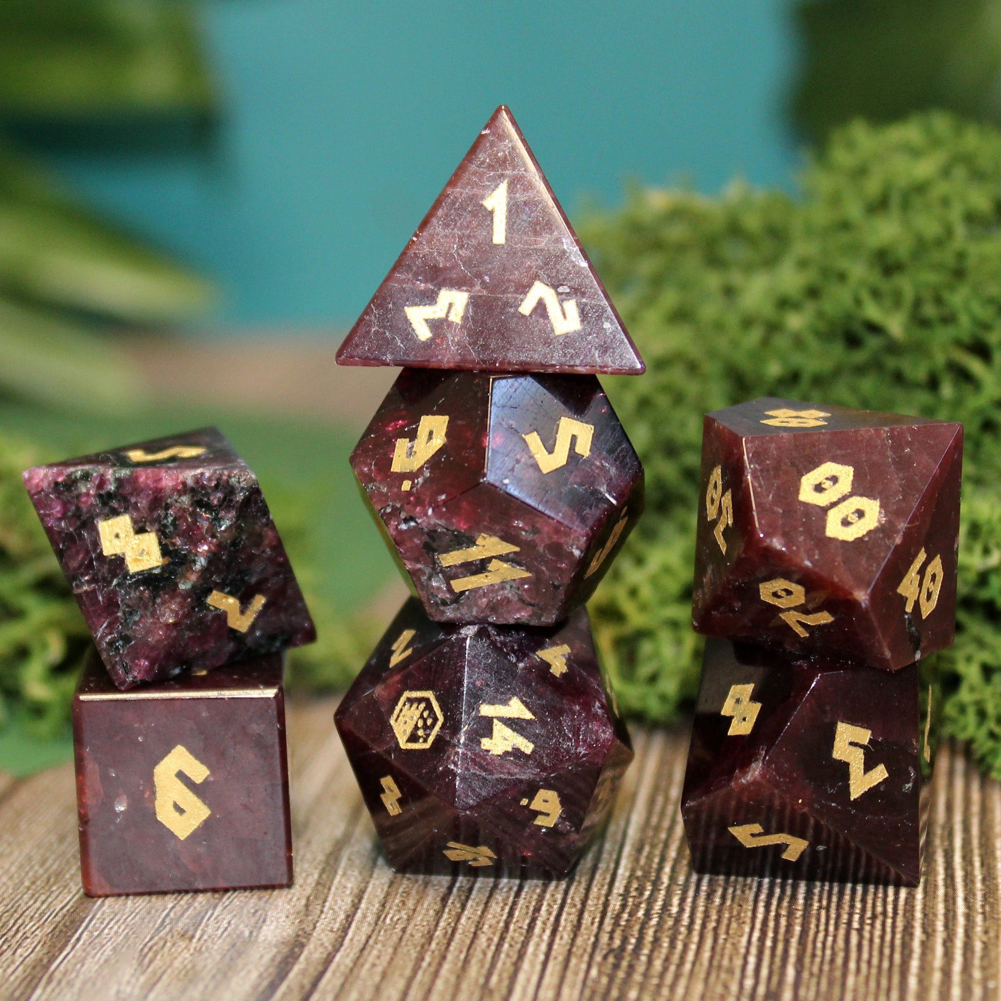 Stacked Garnet gemstone dice set with deep brownish-red hues and gold Romanesque numbering, perfect for Dungeons & Dragons and other RPG games.