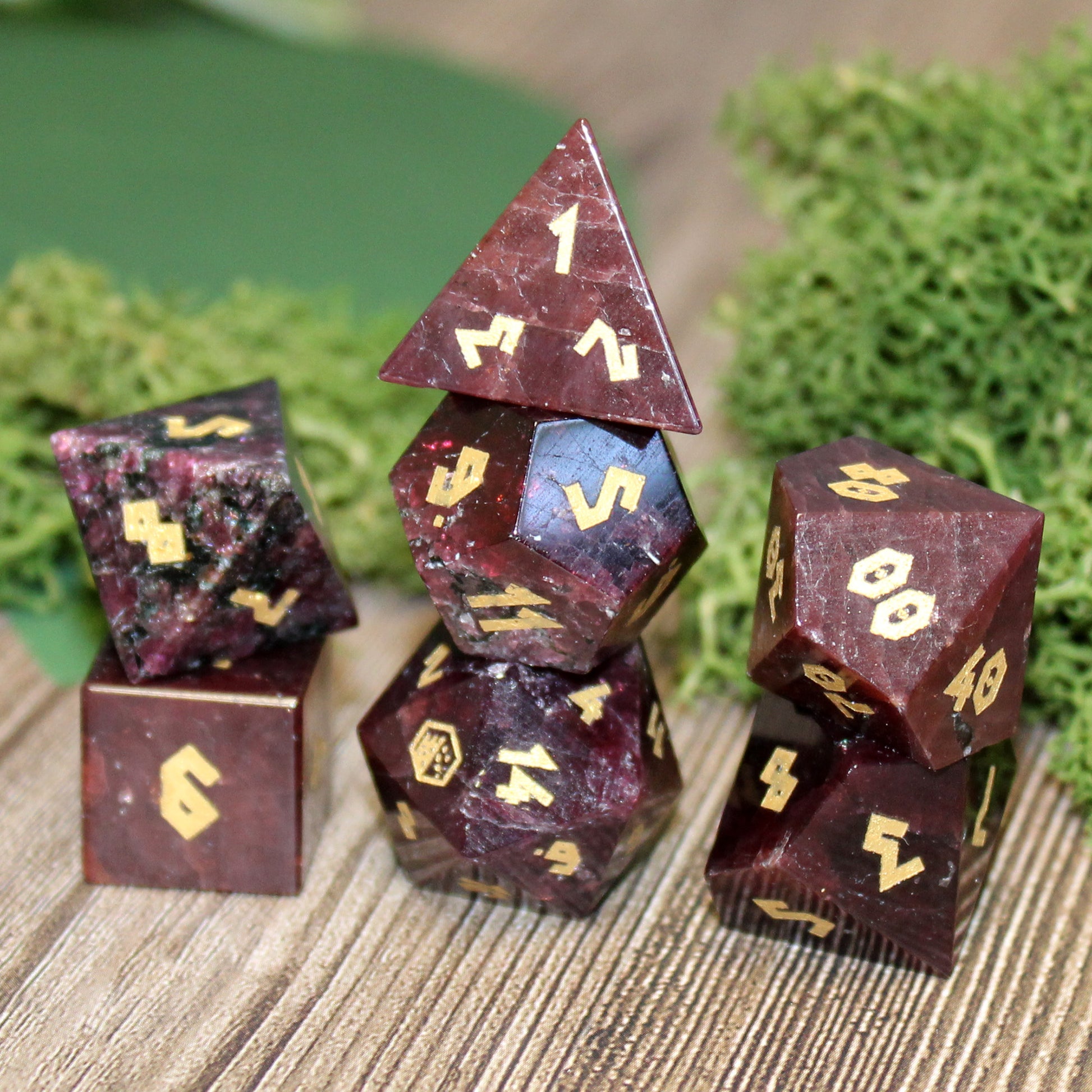 Stacked Garnet dice set on a game table, ready for Dungeons & Dragons or other role-playing games.