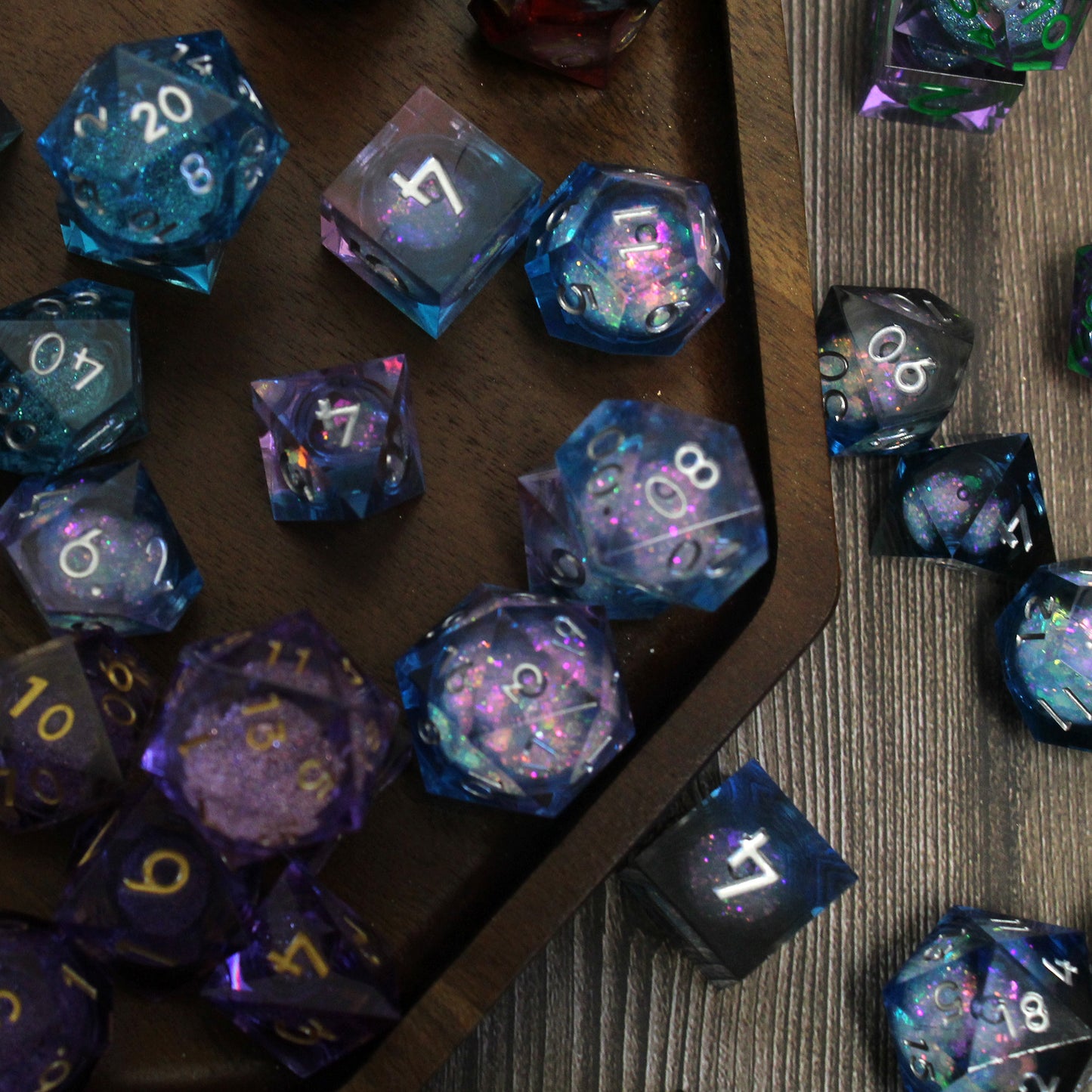 Liquid core resin dice viewed from above in a wooden tray. Each die features a liquid core with a shimmering glitter that delights with each roll.
