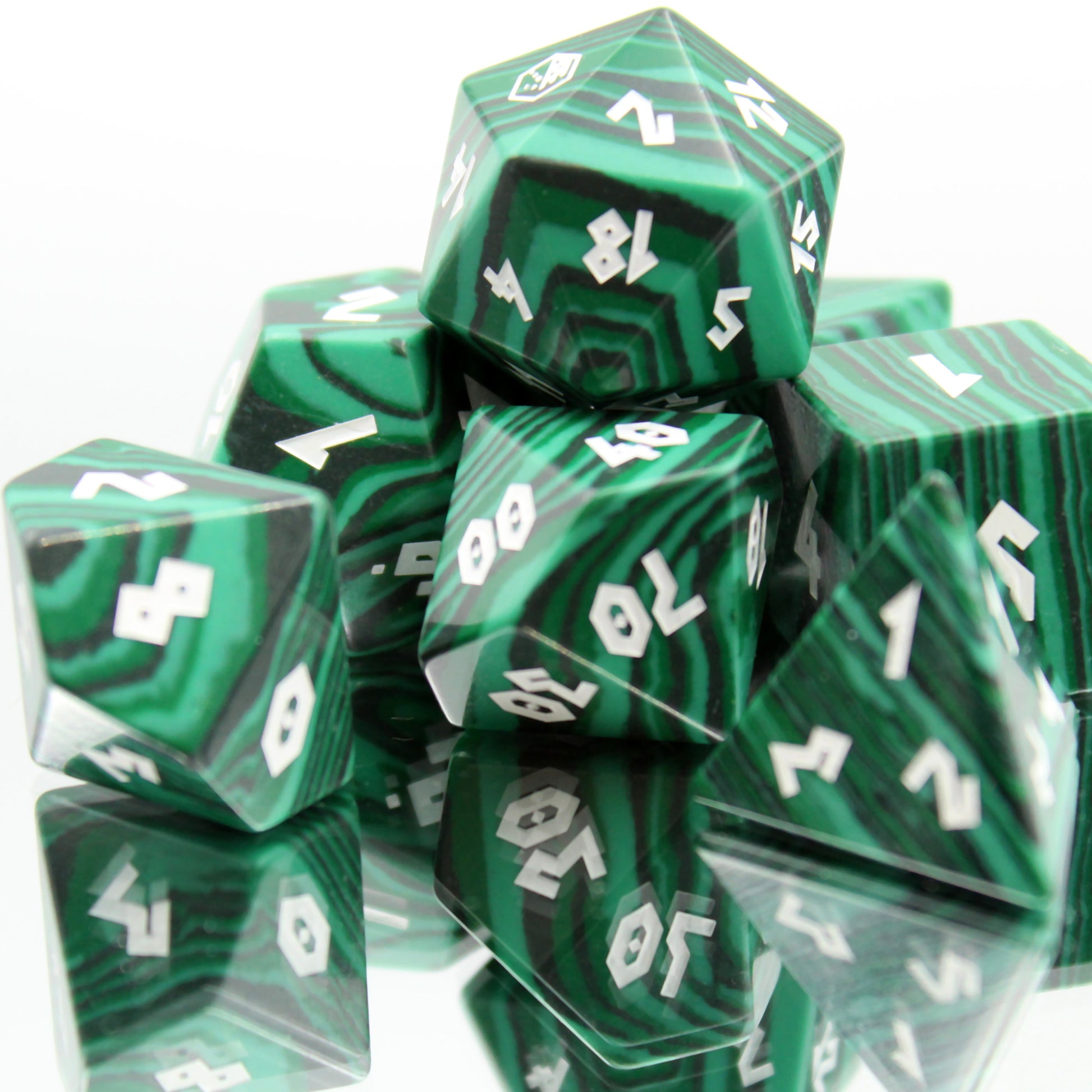 Faux Malachite dice set displayed on a mirror, reflecting natural stone-like appearance perfect for DnD enthusiasts.