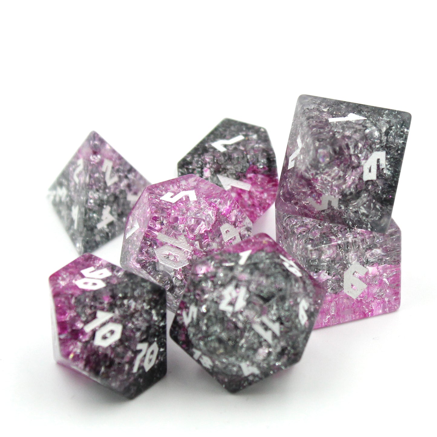 Closeup Shot of Glass dice set on white background highlighting the light refracting through pinks and black.