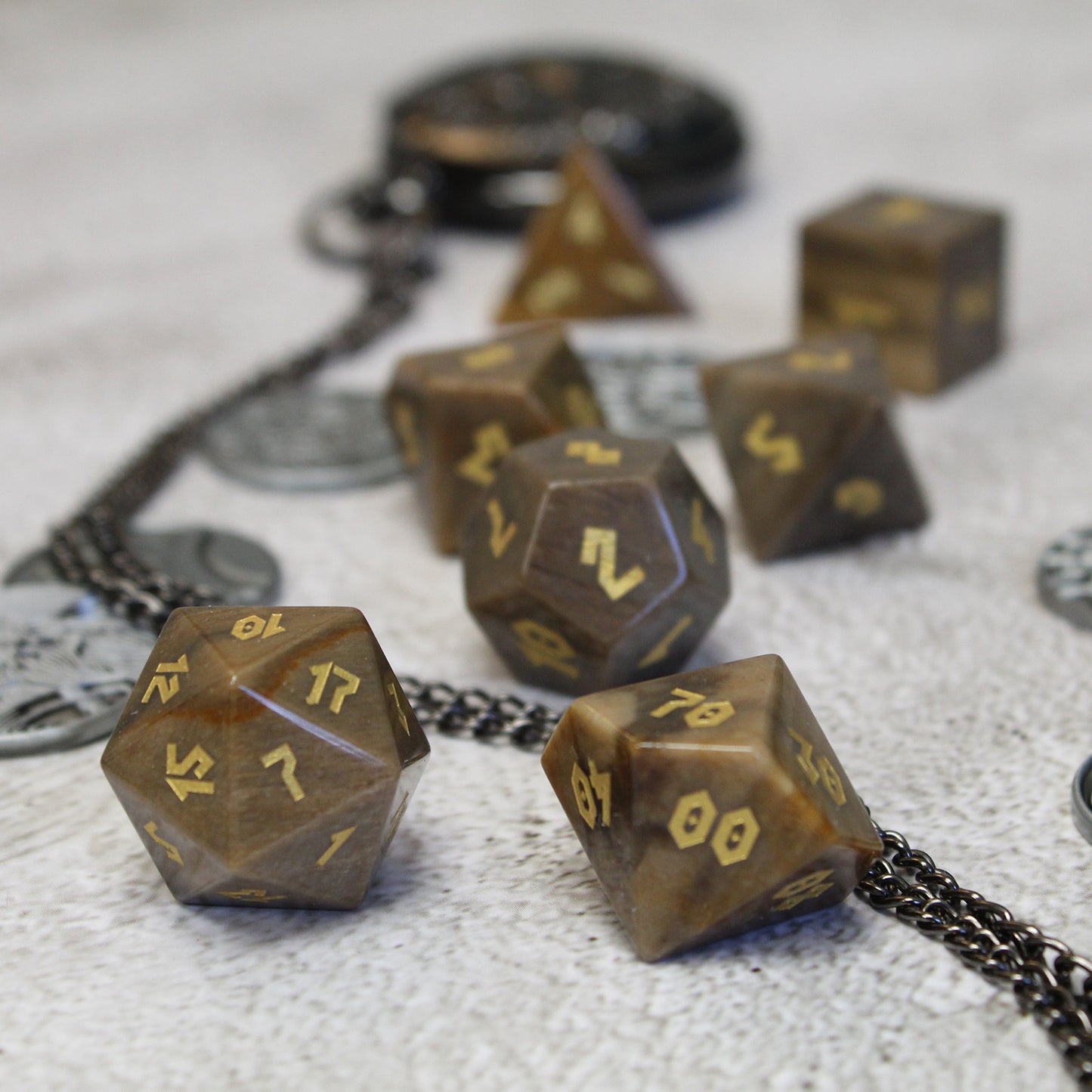 Scattered dice focusing on D100 and D20 with gold Romanesque numbers, ideal for druids and rangers in tabletop RPGs.