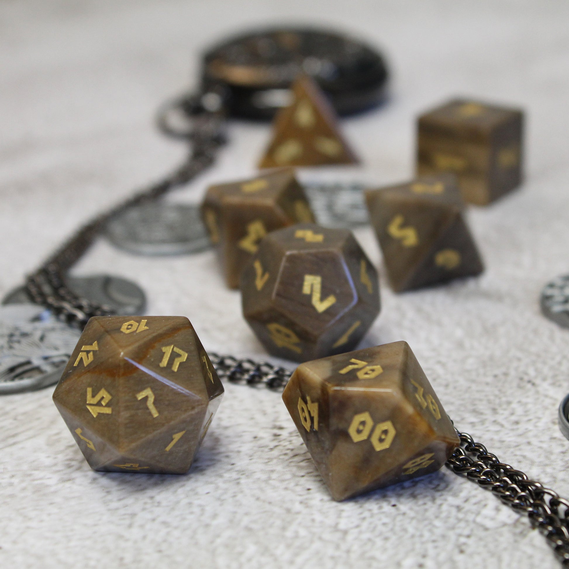 Scattered dice focusing on D100 and D20 with gold Romanesque numbers, ideal for druids and rangers in tabletop RPGs.