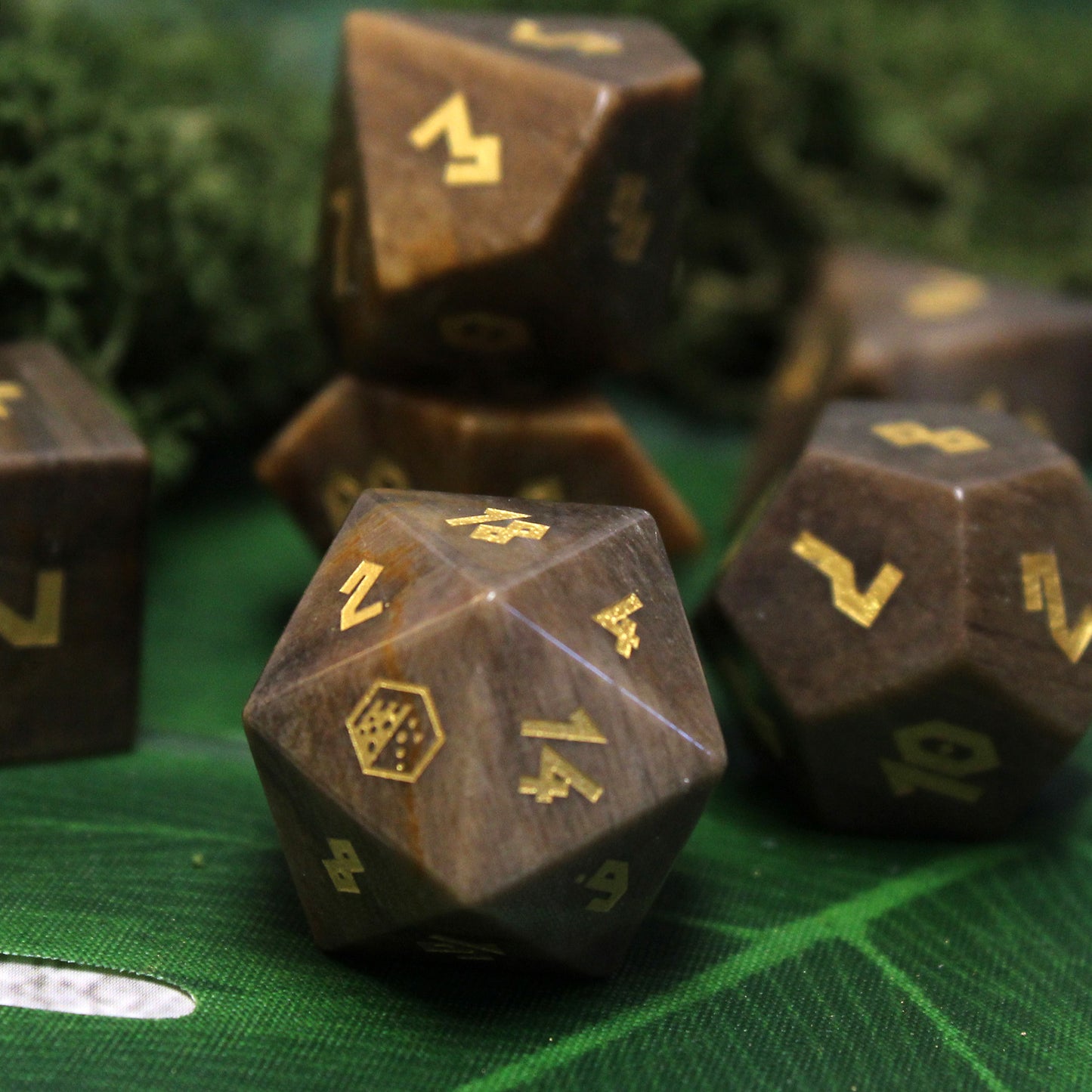Dice made from petrified wood, inked with bright gold foil for dnd games. Features the Dice Dungeons logo on the 20.