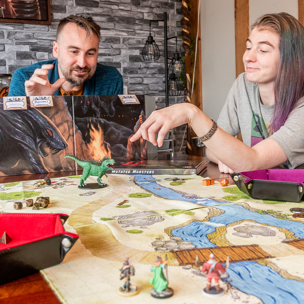 Photo of two people playing a tabletop RPG and using a cloth battle map