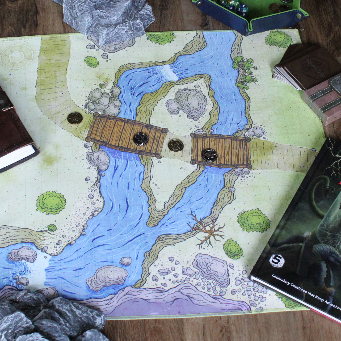 Overhead photo of a bridge battle map with metal tokens placed on it