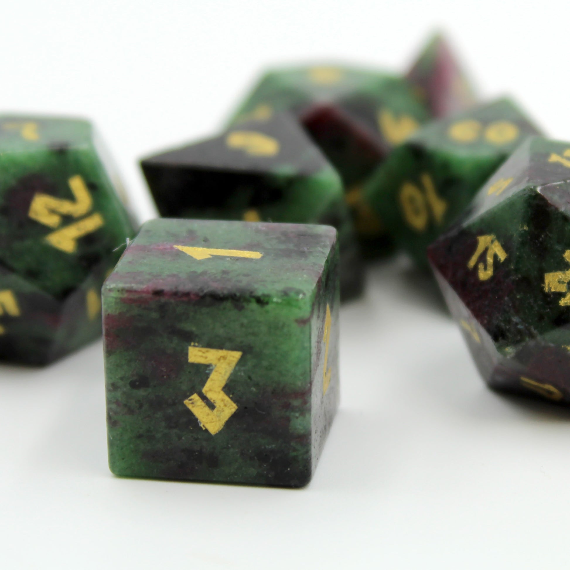 Close-up of the D6 die from the Ruby Zoisite set, with shining gold color font.