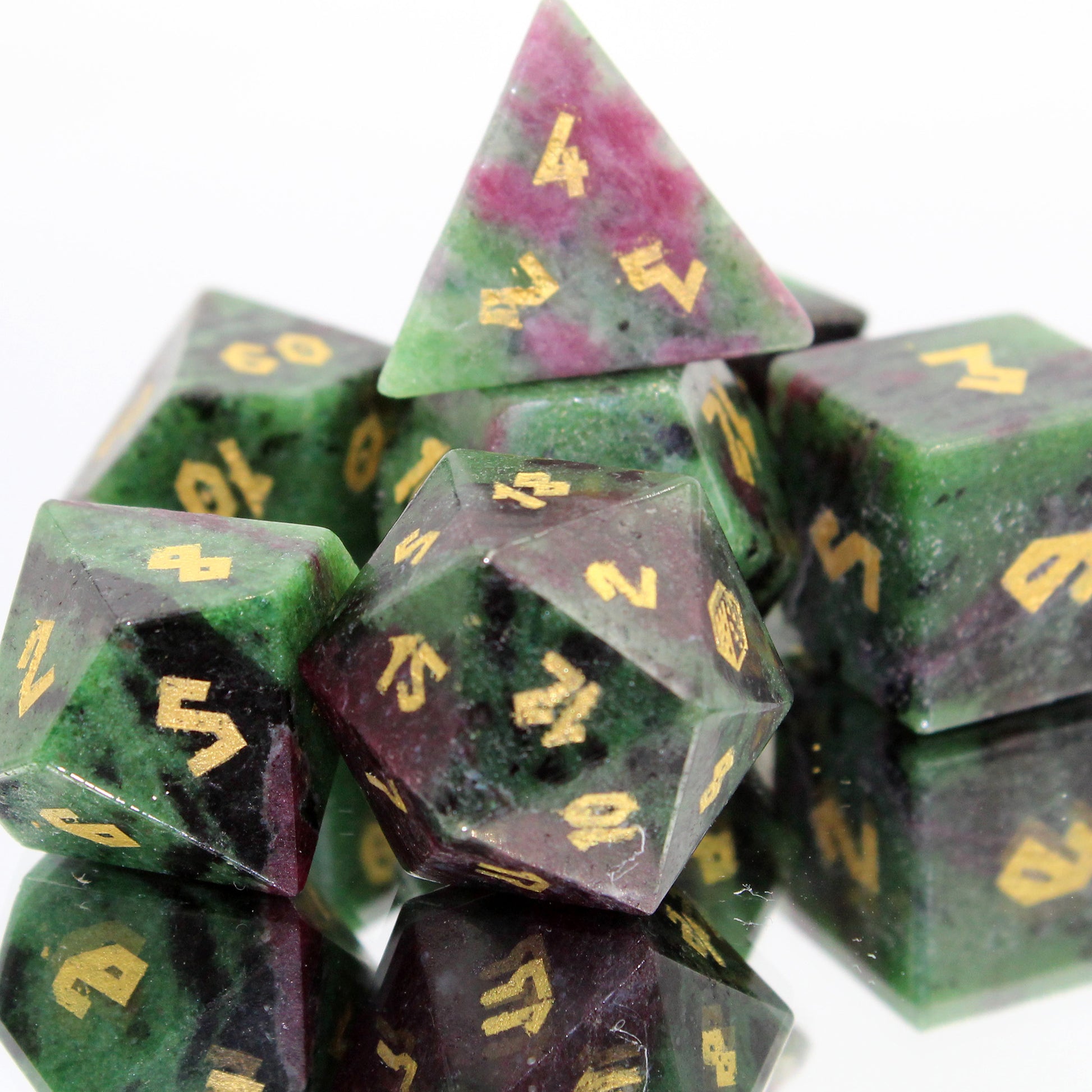 Stacked Ruby Zoisite dice reflecting light, emphasizing the unique blend of ruby and zoisite minerals for RPG enthusiasts.
