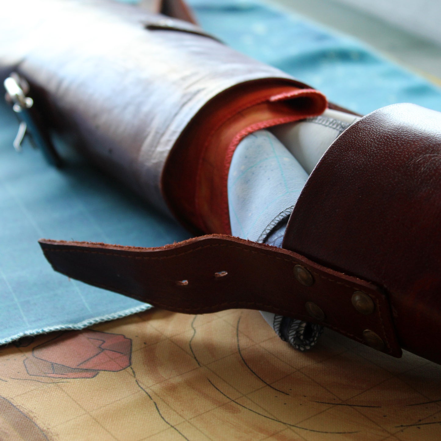 Close-up of a leather scroll case sheath on a map.