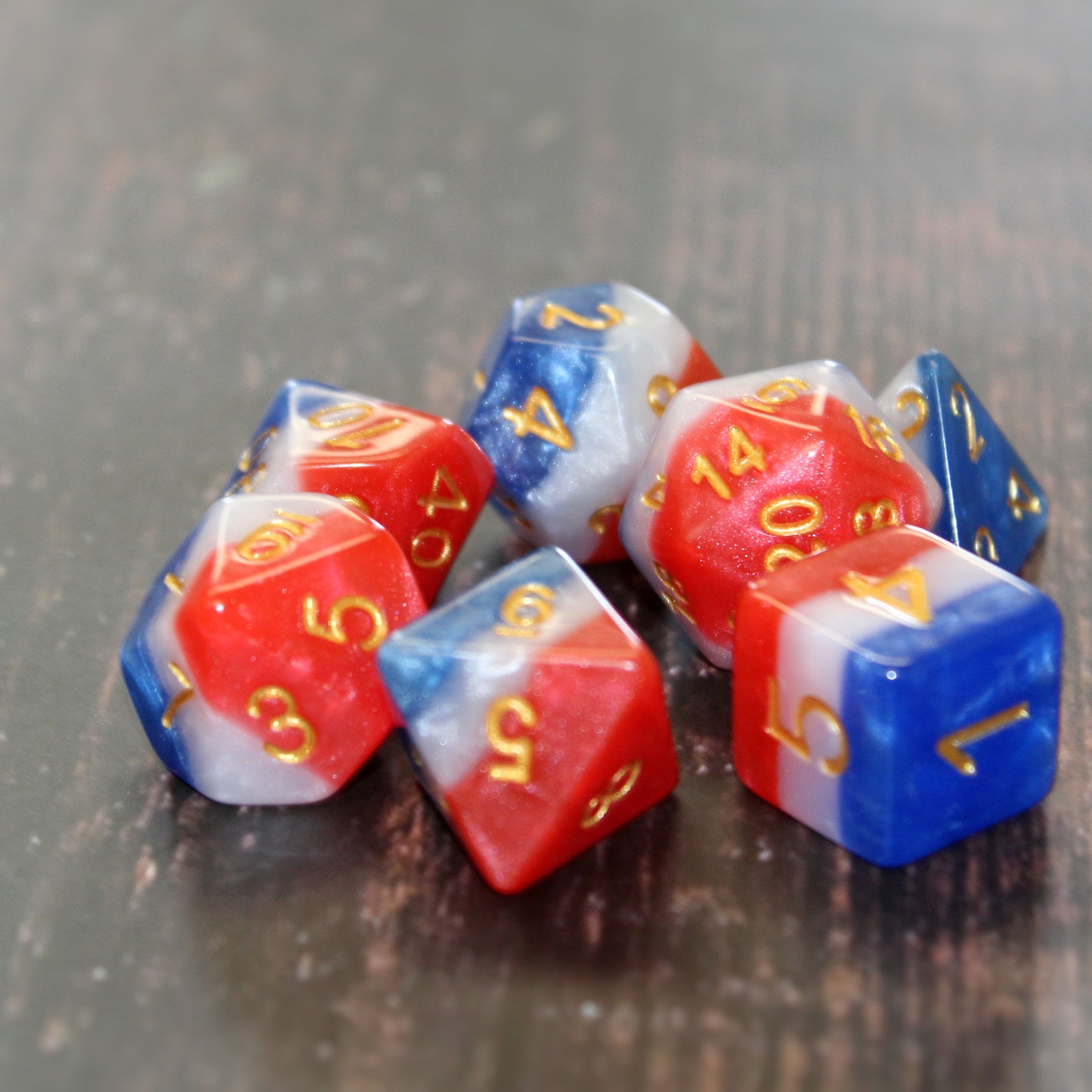 layered usa dice for dungeons and drgons on a wooden table top.