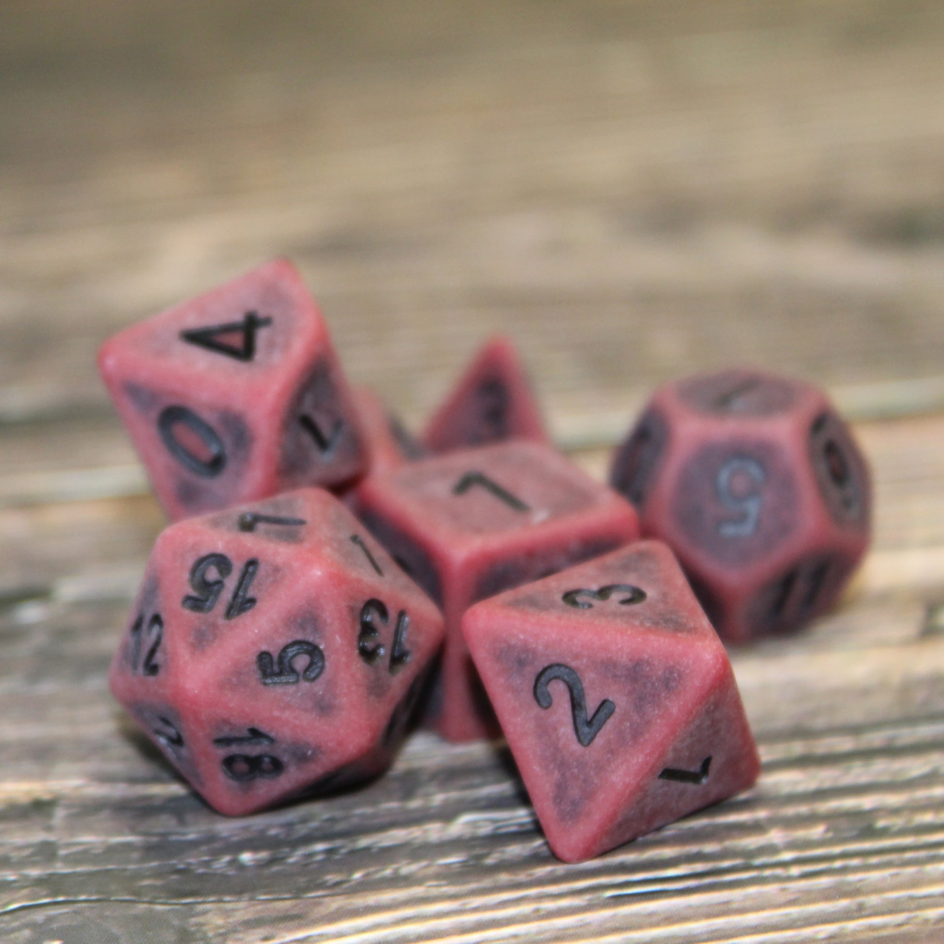 Full set of weathered dice in blood red, featuring a rough texture and black-inked, easy-to-read numbers, ideal for hardened adventurers in RPG gameplay.