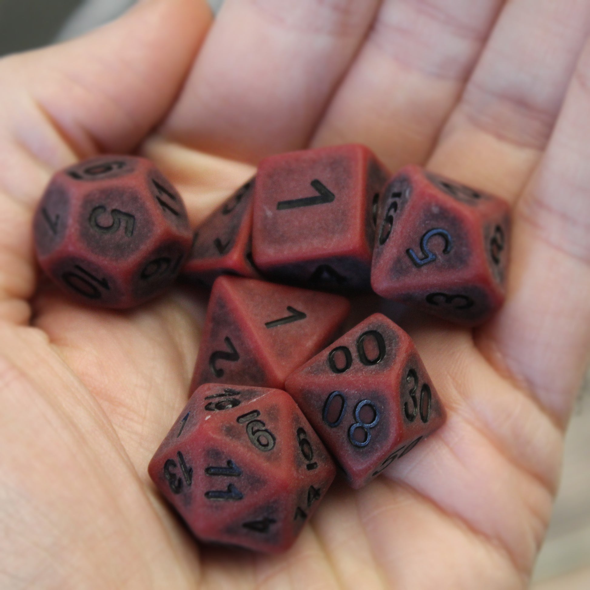 Antiqued plastic dice set in hand for size comparison - these are 16mm, a standard size for dnd dice.