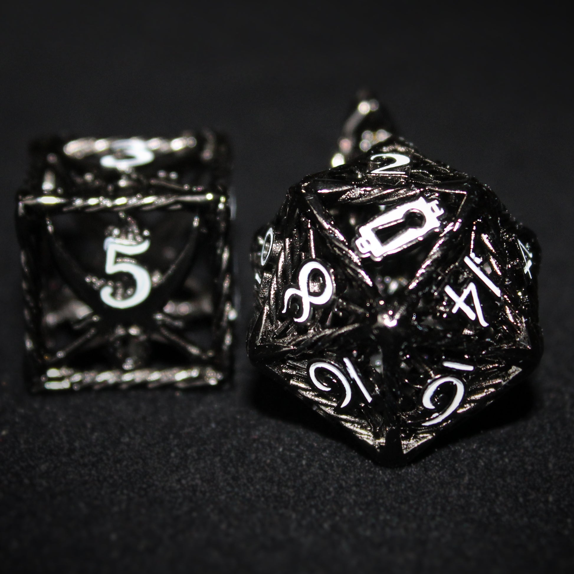 Black D20 and D6 Rogue Cage dice on a black background. The D6 is on the left with the white 5 facing forward, and the D20 is on the right with the white keyhole facing forward, replacing the 20.