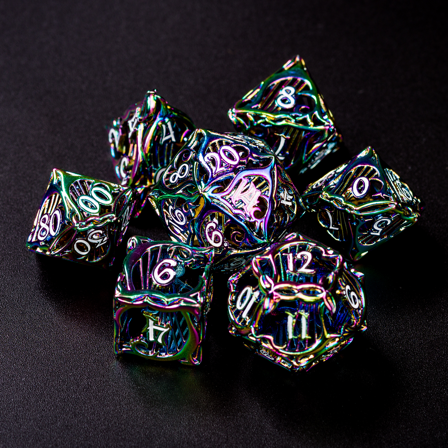 Set of seven multicolored bard-inspired hollow metal dice with white numbers on a black background