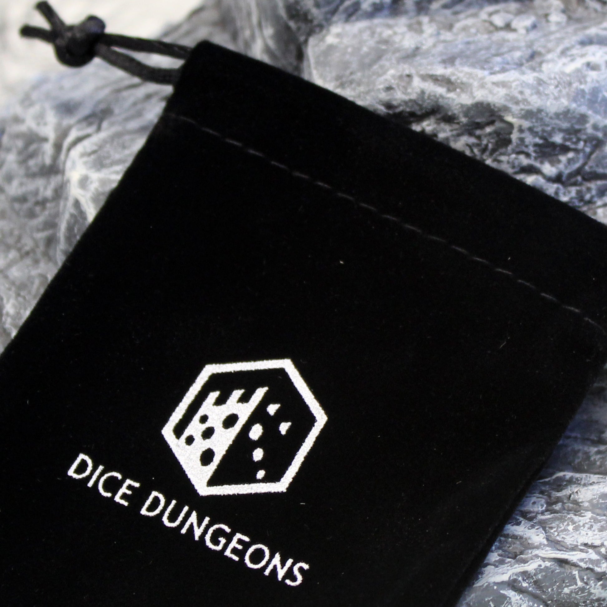 Closup of the dice dungeons logo on their dice bag.