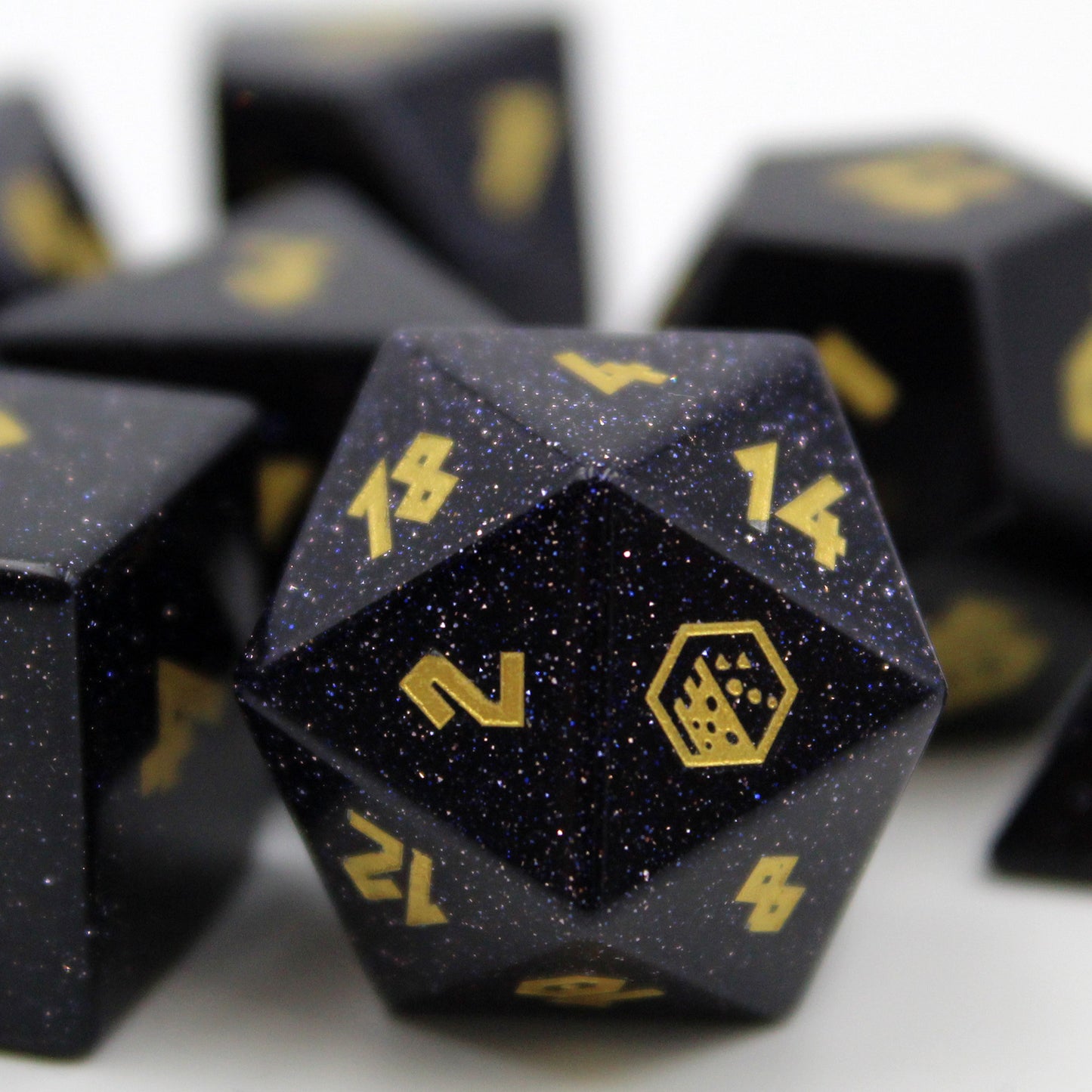 Closup of the d20 of the Blue Goldstone Dice Set from Dice Dungeons. With logo in gold-color on the 20.