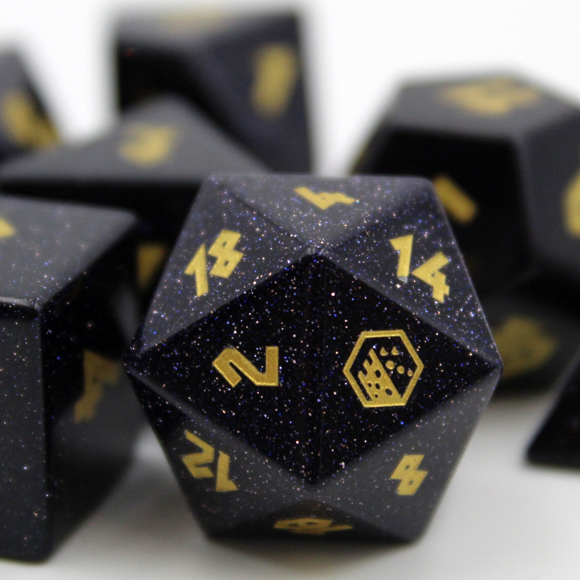 Closup of the d20 of the Blue Goldstone Dice Set from Dice Dungeons. With logo in gold-color on the 20.