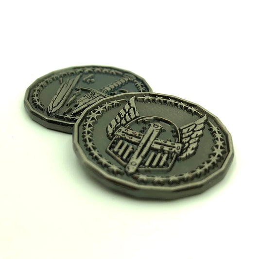Dice Dungeons' Paladin Character Coin in an antique silver finish front and back on a white surface. The front face overlaps the back face and has a winged helmet encircled by stars while the back face has a broken sword surrounded by the same ring of stars.