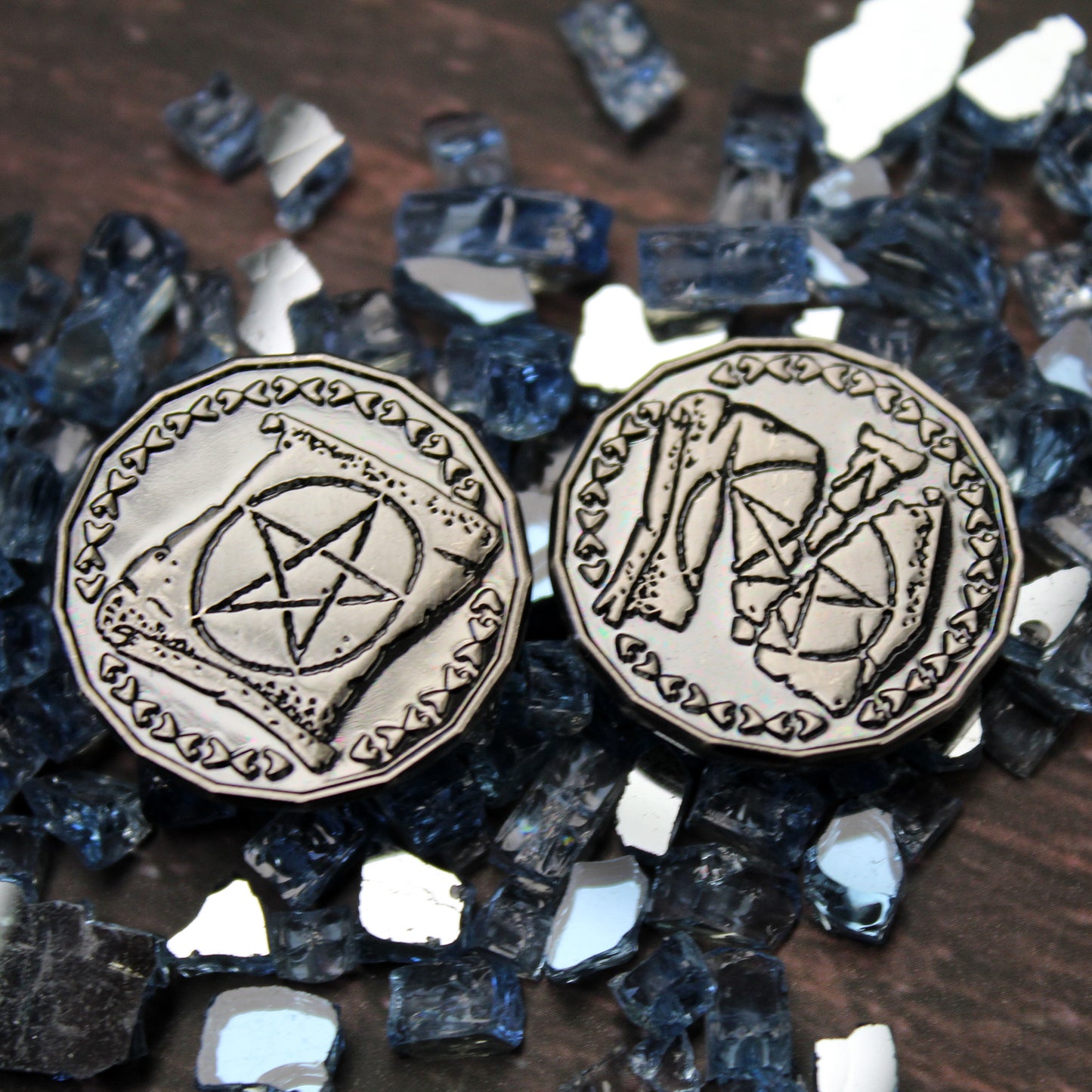 Close Up of Two Silver Warlock Tokens, Heads and Tails, on a Wood Background