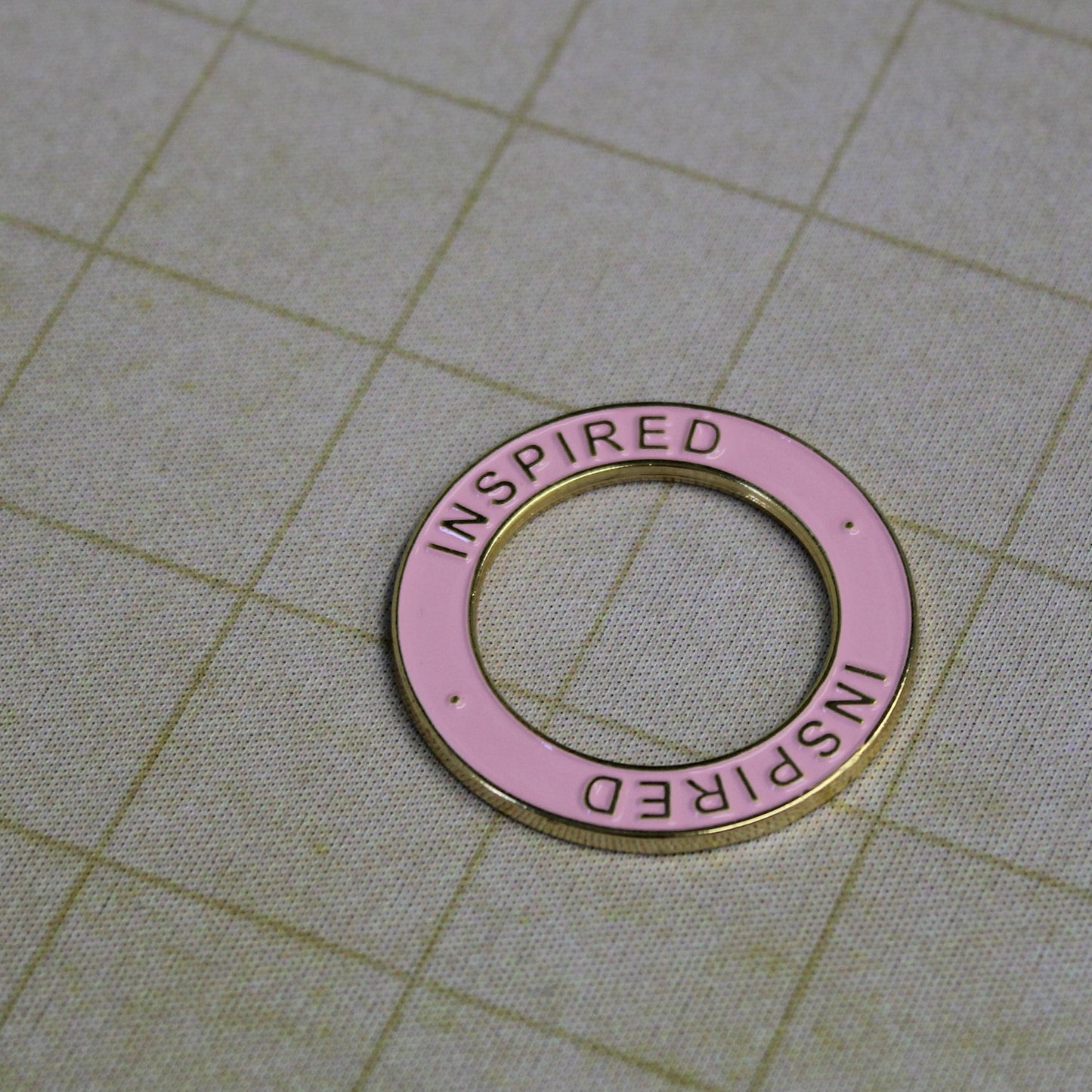 Gold and pink Inspired condition ring placed on a miniature on a gridded battlemap, helping track inspiration for characters and monsters in tabletop RPGs.