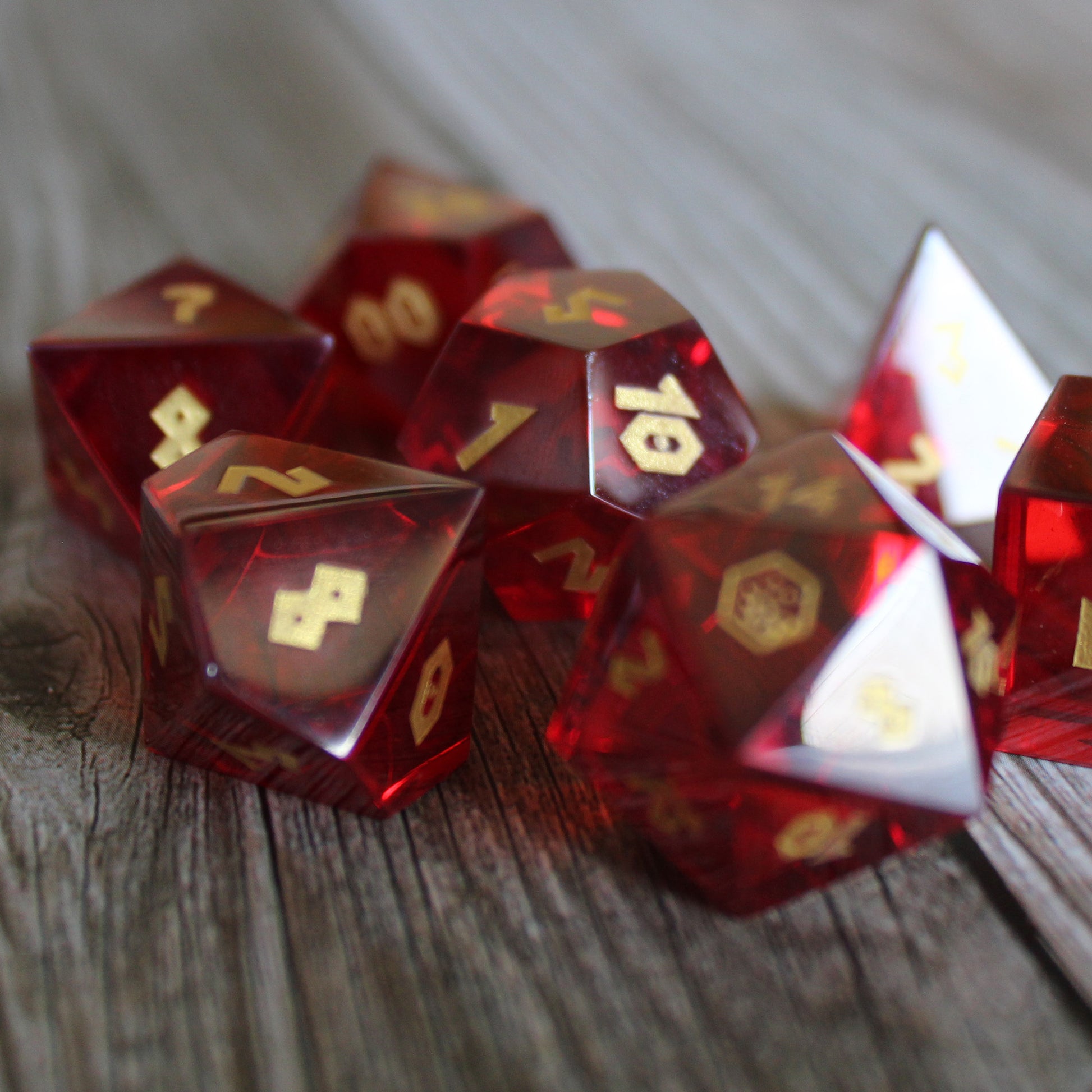 Red Cubic Zirconia dice set on a table, with a gemstone-like finish and gold numbering.