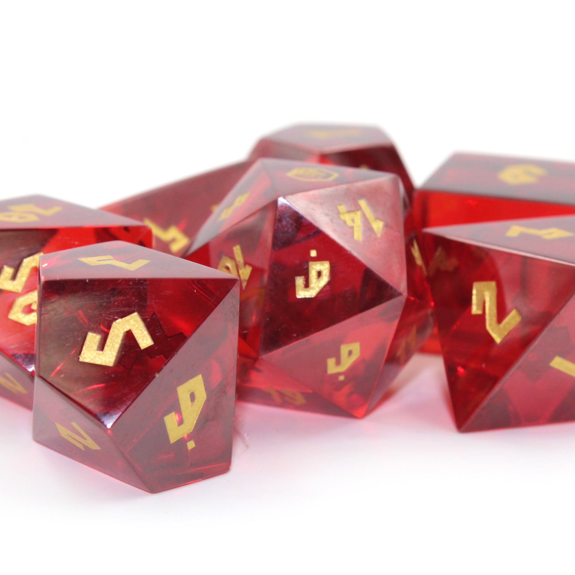 Close-up of Red Cubic Zirconia dice set for Dungeons & Dragons, with polished surfaces and gold numbering.