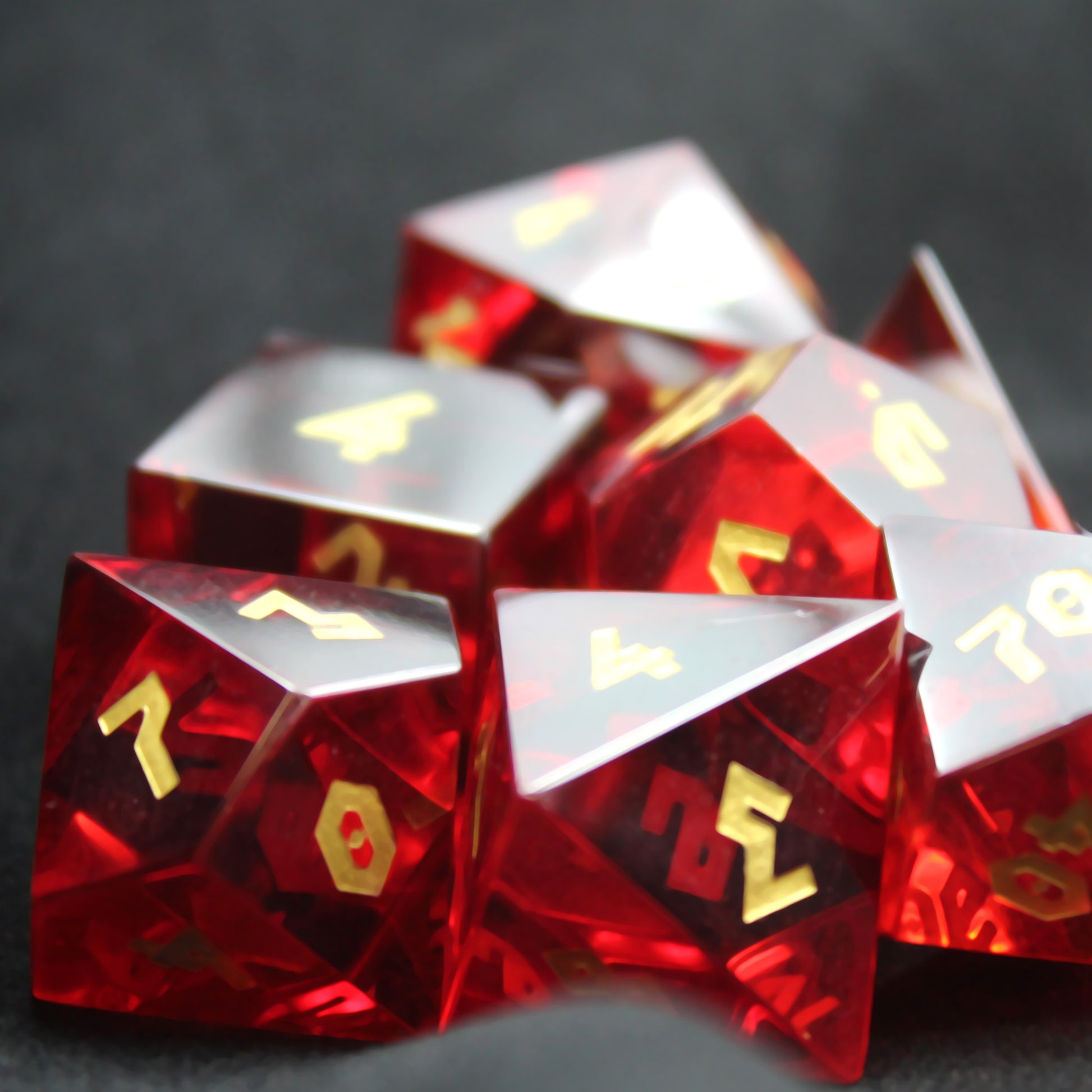 Close-up of Red Cubic Zirconia dice set with a reflective surface and gold numbering.