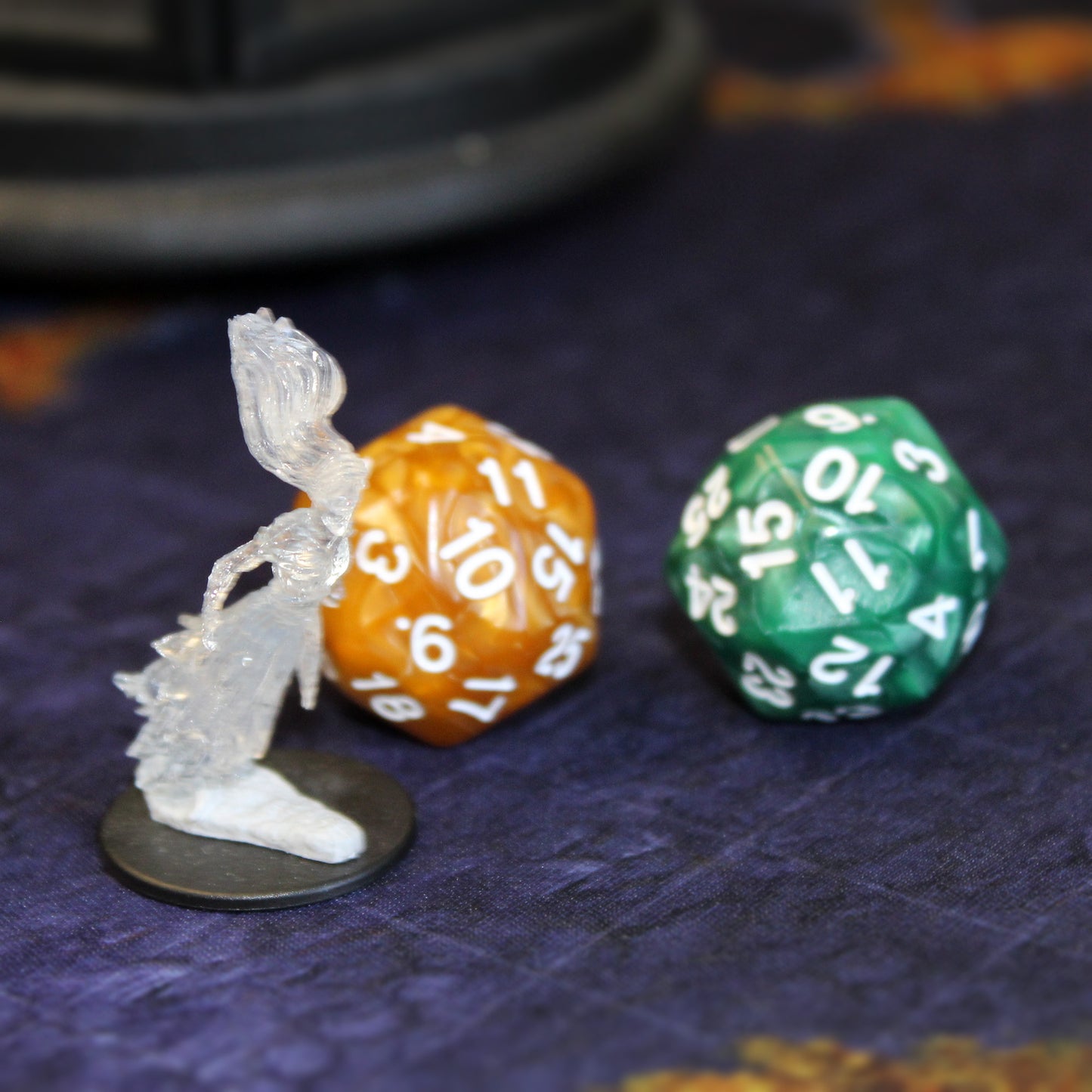 Green and orange D30 dice side by side, featuring pearlescent finishes and contrasting white numbering.