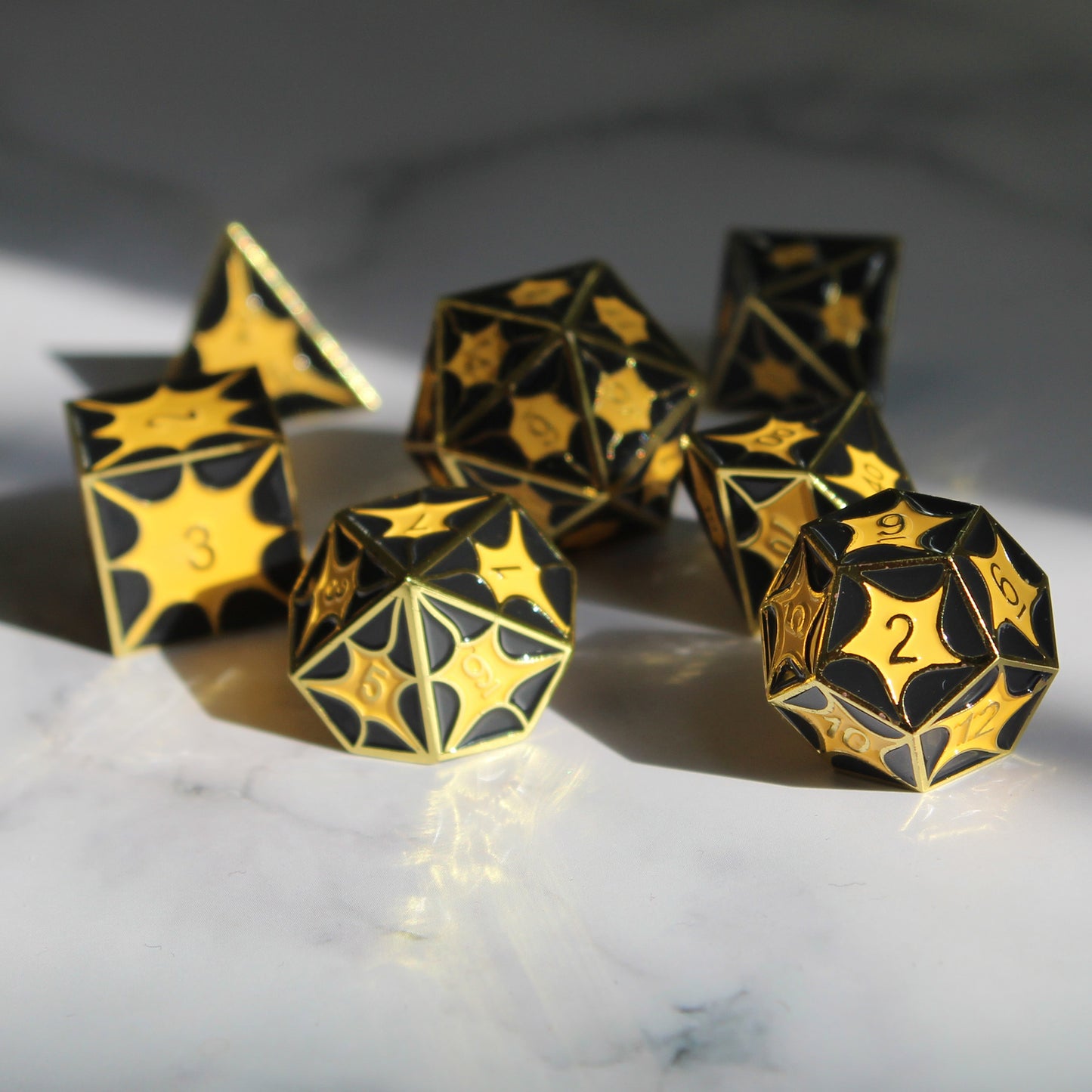 Black dragon pattern metal dice set displayed on marble, accentuating the electroplated metallic coat for RPG games.