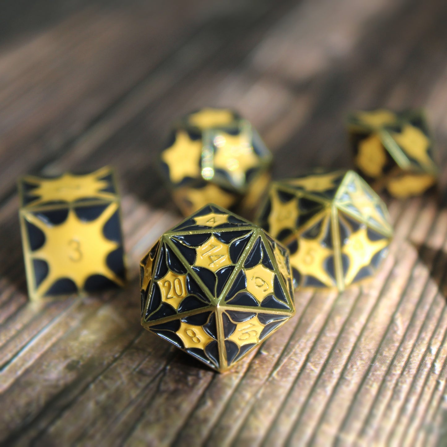 Set of black dragon pattern metal dice displayed on a wooden table, showcasing intricate scales ideal for Dungeons and Dragons.