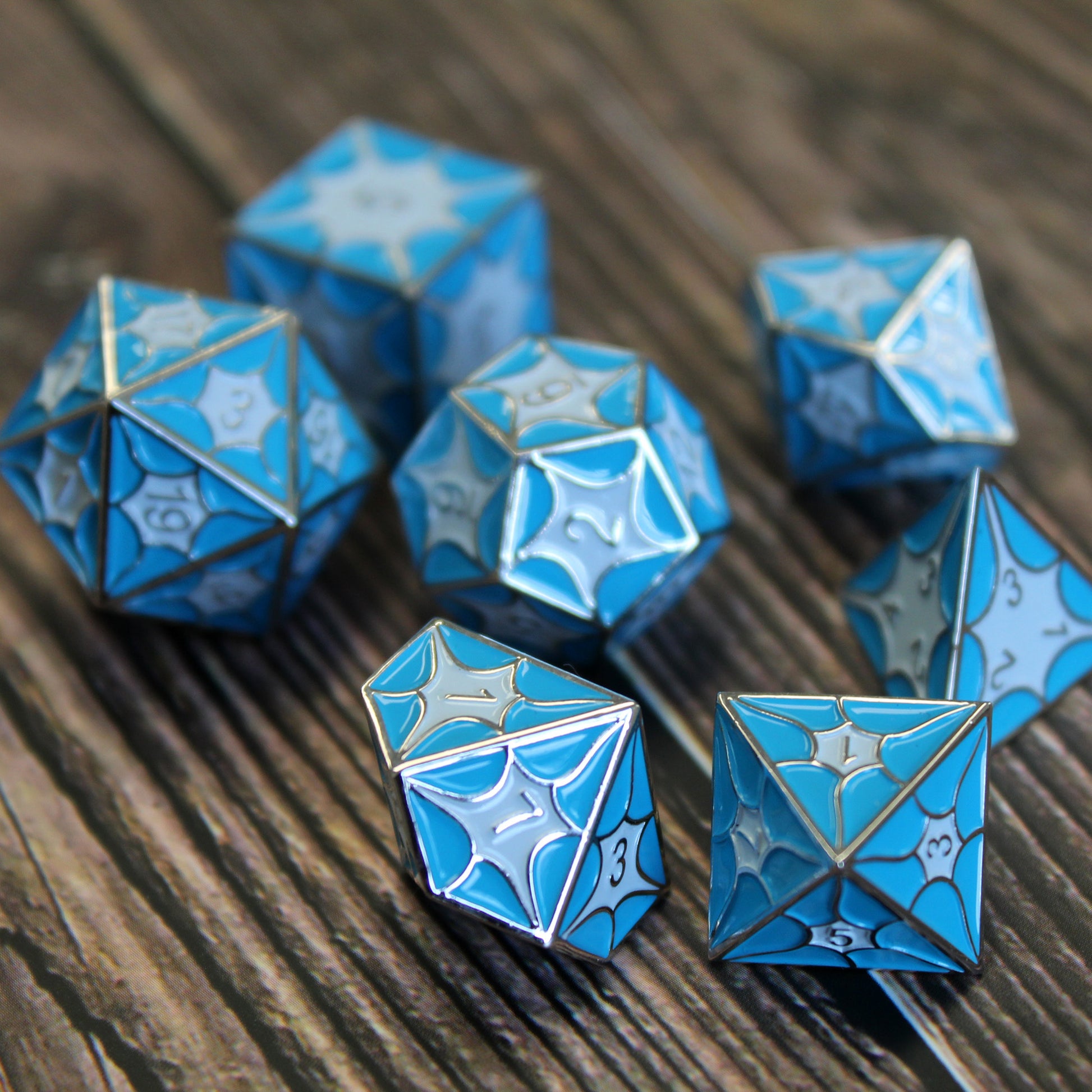 Blue dragon inspired dice set on a table, with bright blue enamel ideal for Dungeons and Dragons.