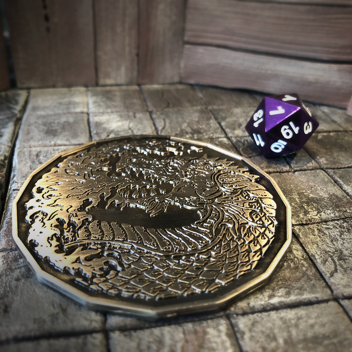 Adult Fire Dragon monster token placed on a dark leather tabletop, next to a purple d20 to showcase the size of the 2 inch coin.