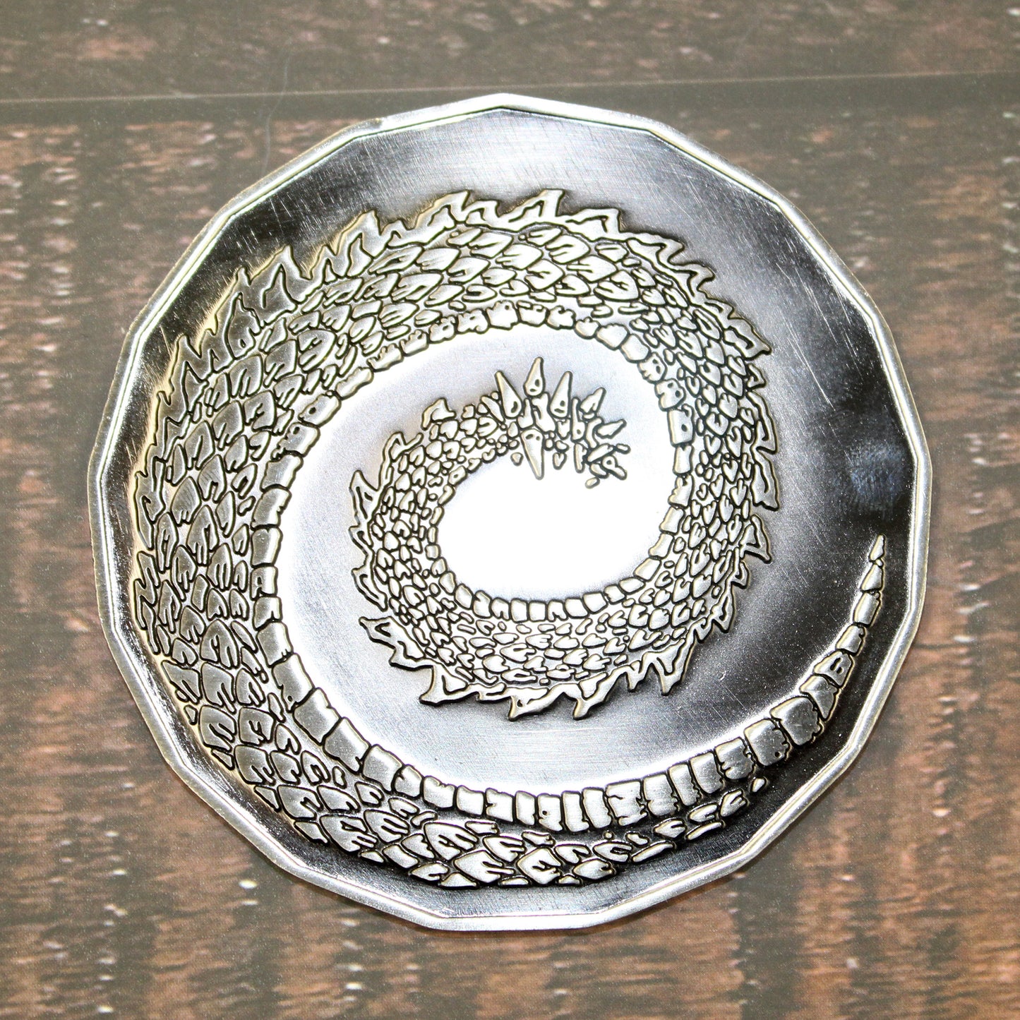 Adult Fire Dragon token on a wooden table, the back side is down showing the dragon tail.