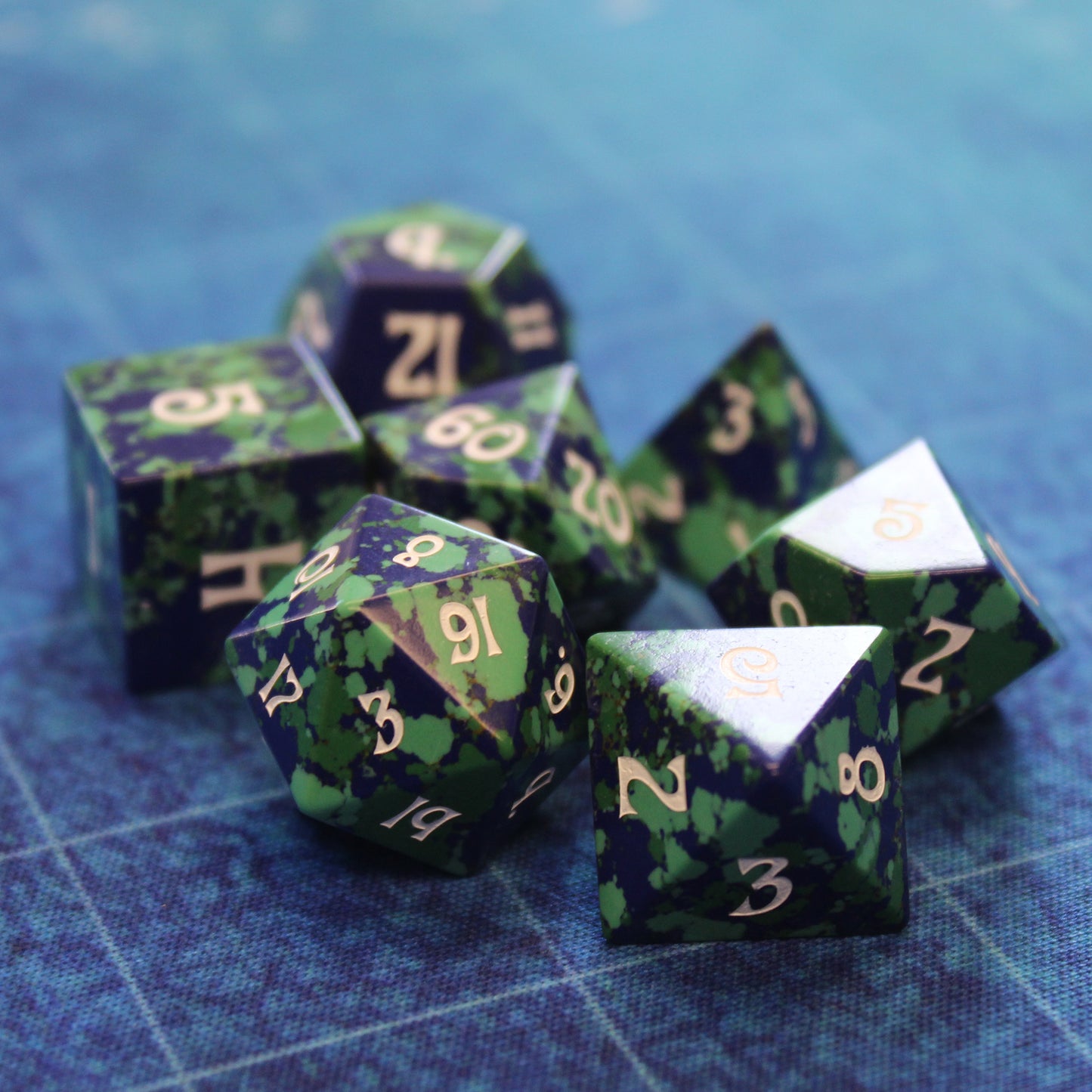 Gaia Dice Set on blue battlemap, enhancing your DnD sessions with vibrant greens and blues.