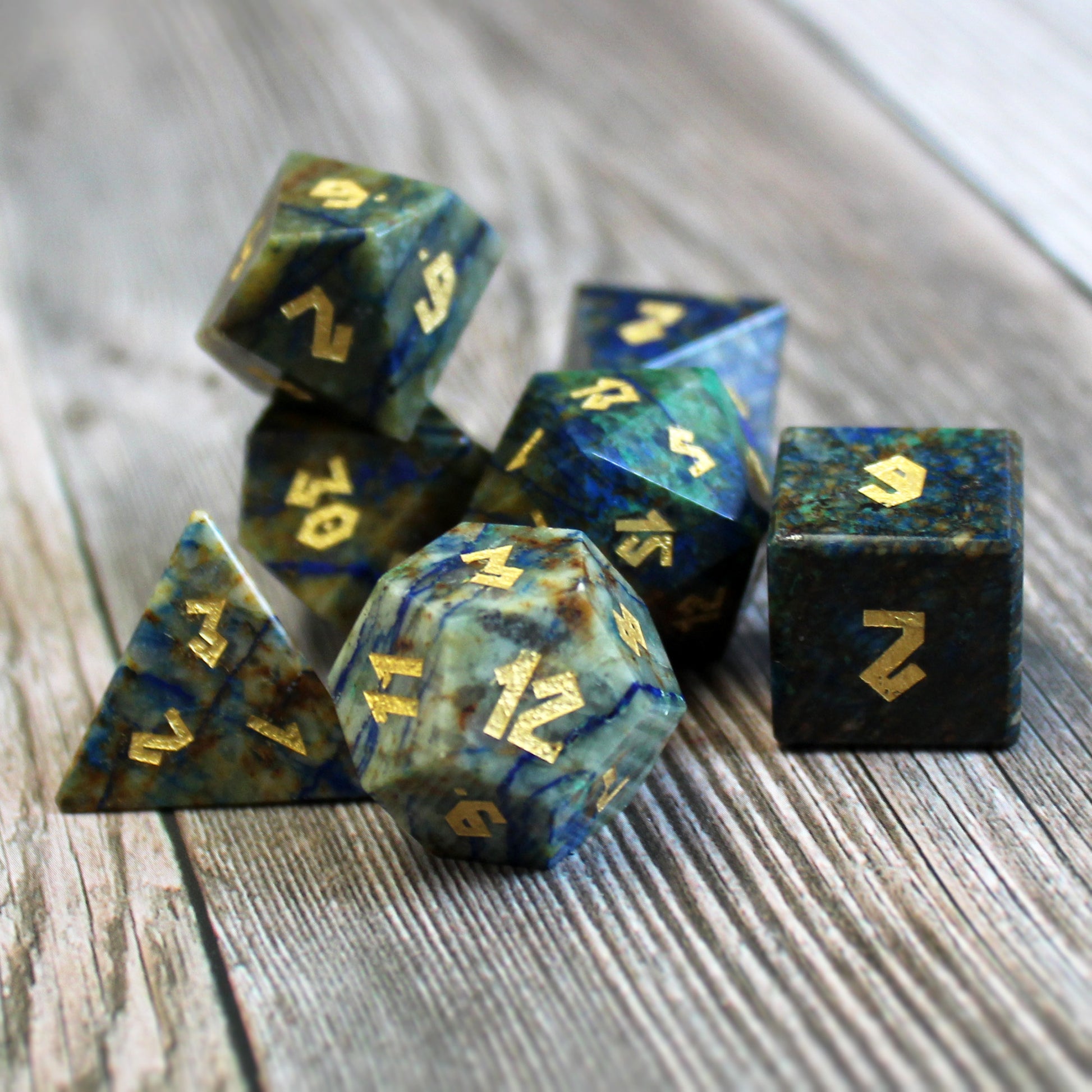 Azurite dice set scattered on a wooden surface