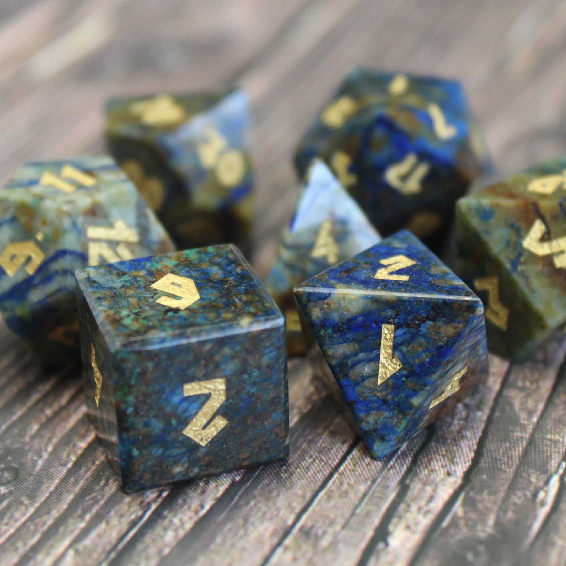 Azurite dice set scattered on a wooden surface
